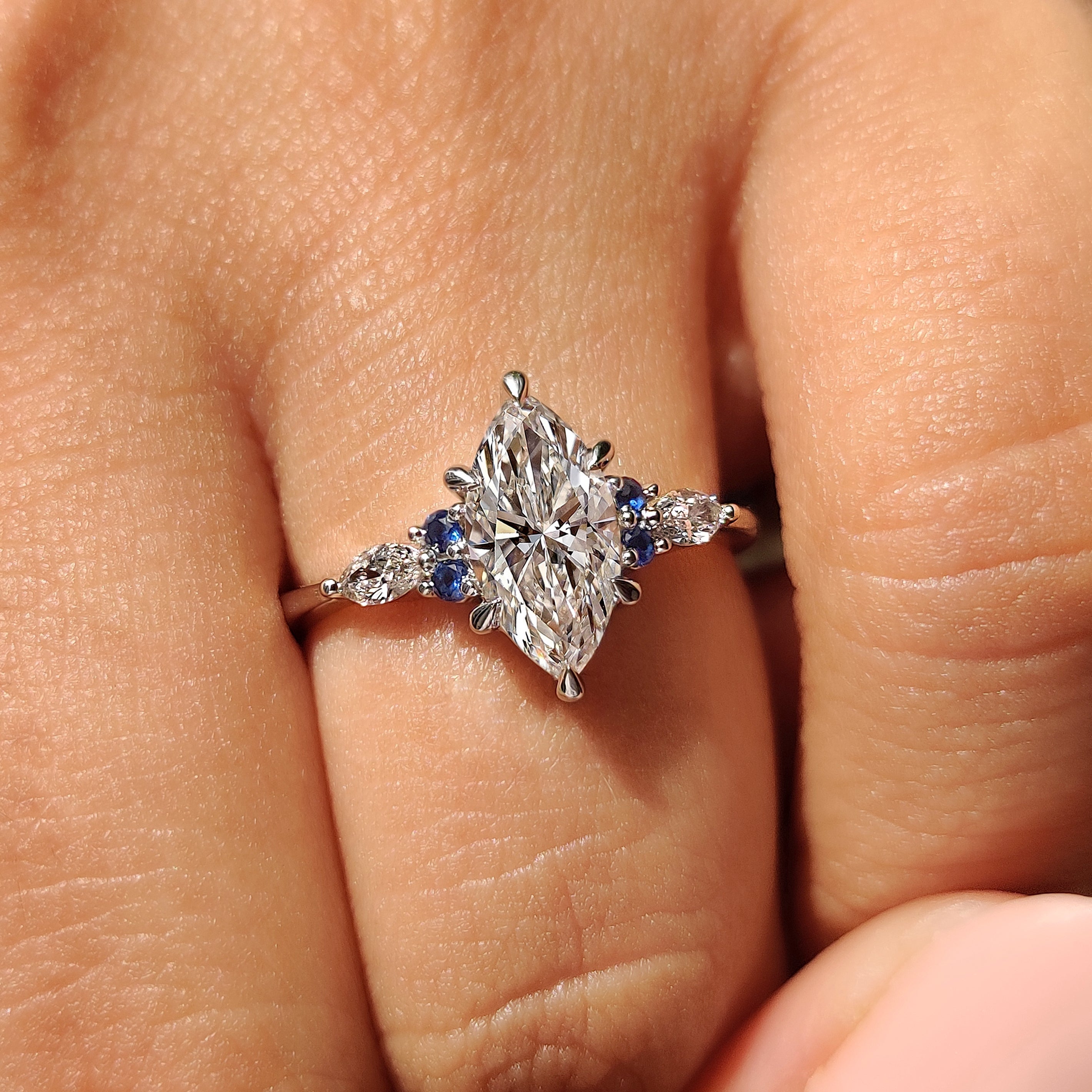 Marquise diamond ring with round blue sapphire accents
