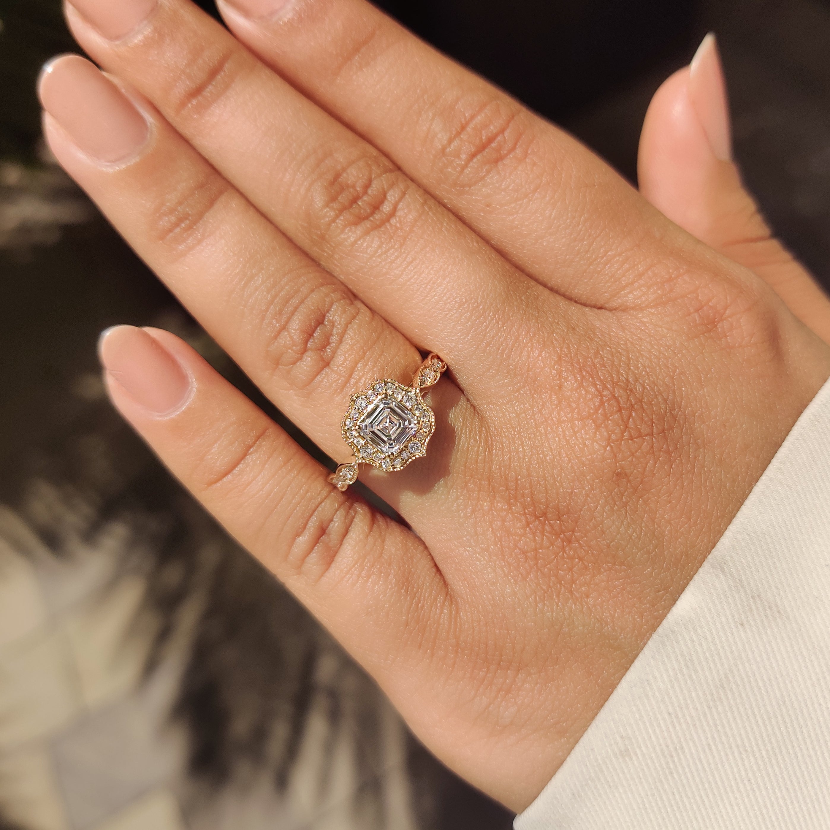 Asscher diamond ring with round cut halo and pave band.
