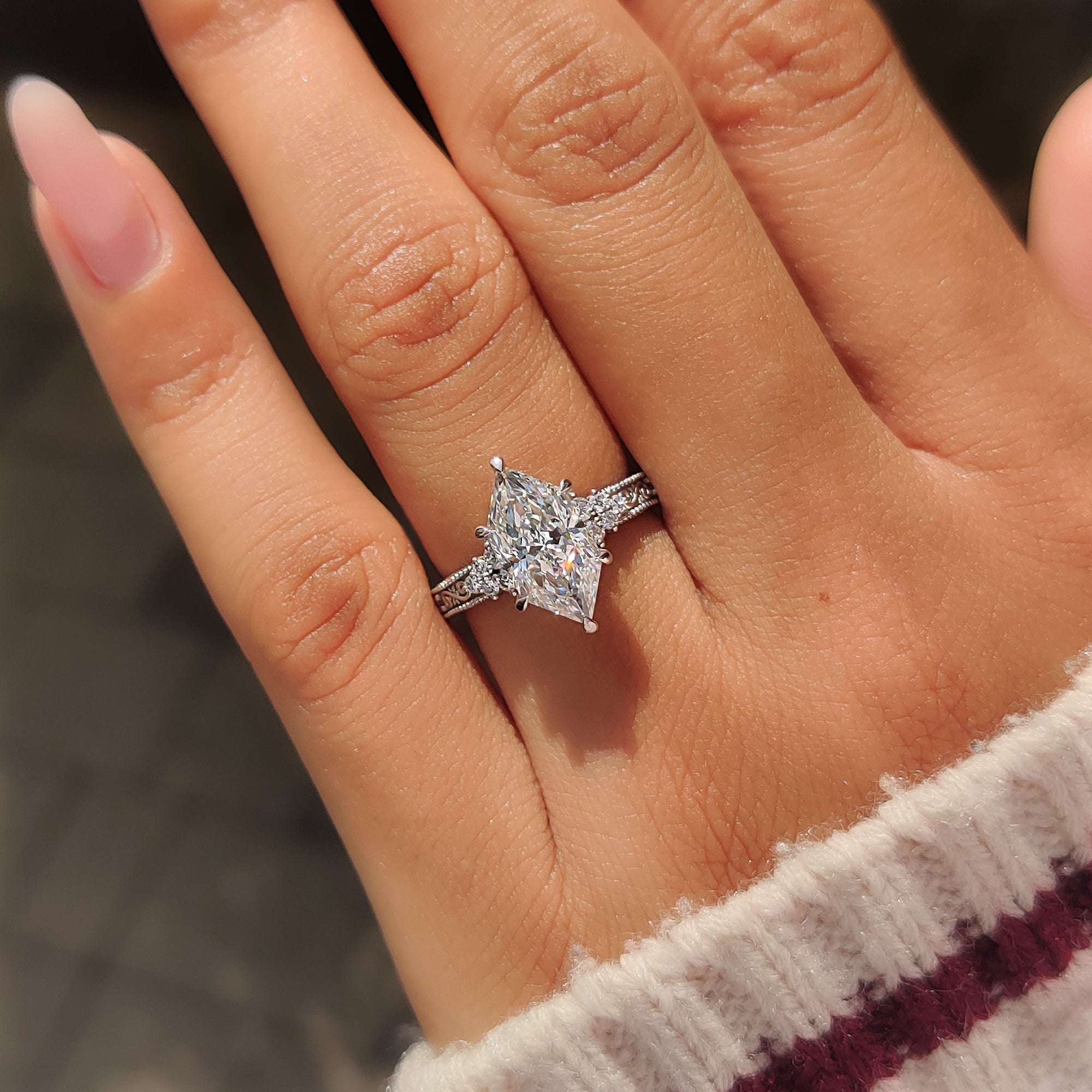 Six claw prongs securing the Dutch marquise center diamond.
