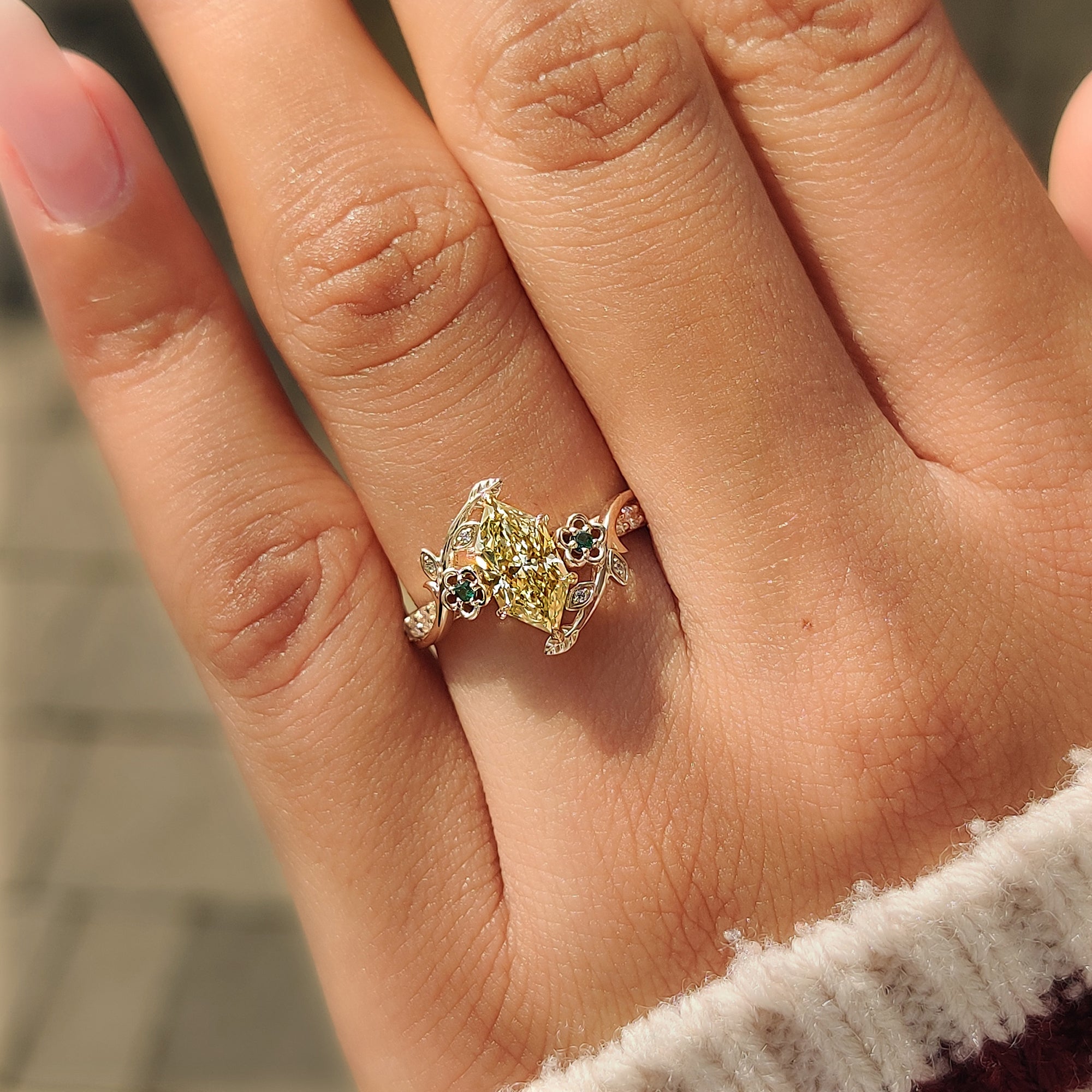 Green round side stones on a yellow Dutch marquise ring.
