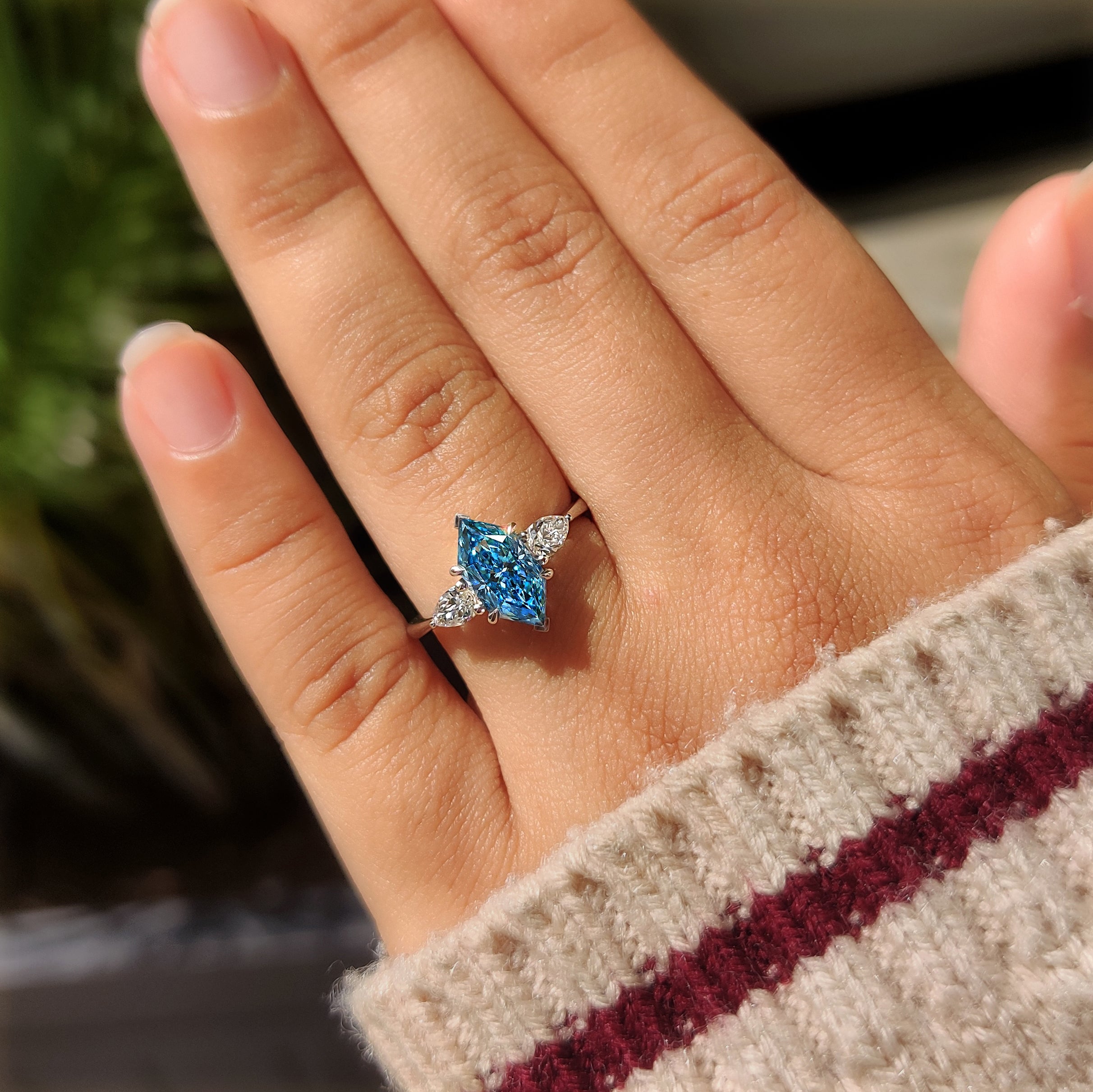 Blue dutch marquise center diamond secured by four claw prong setting
