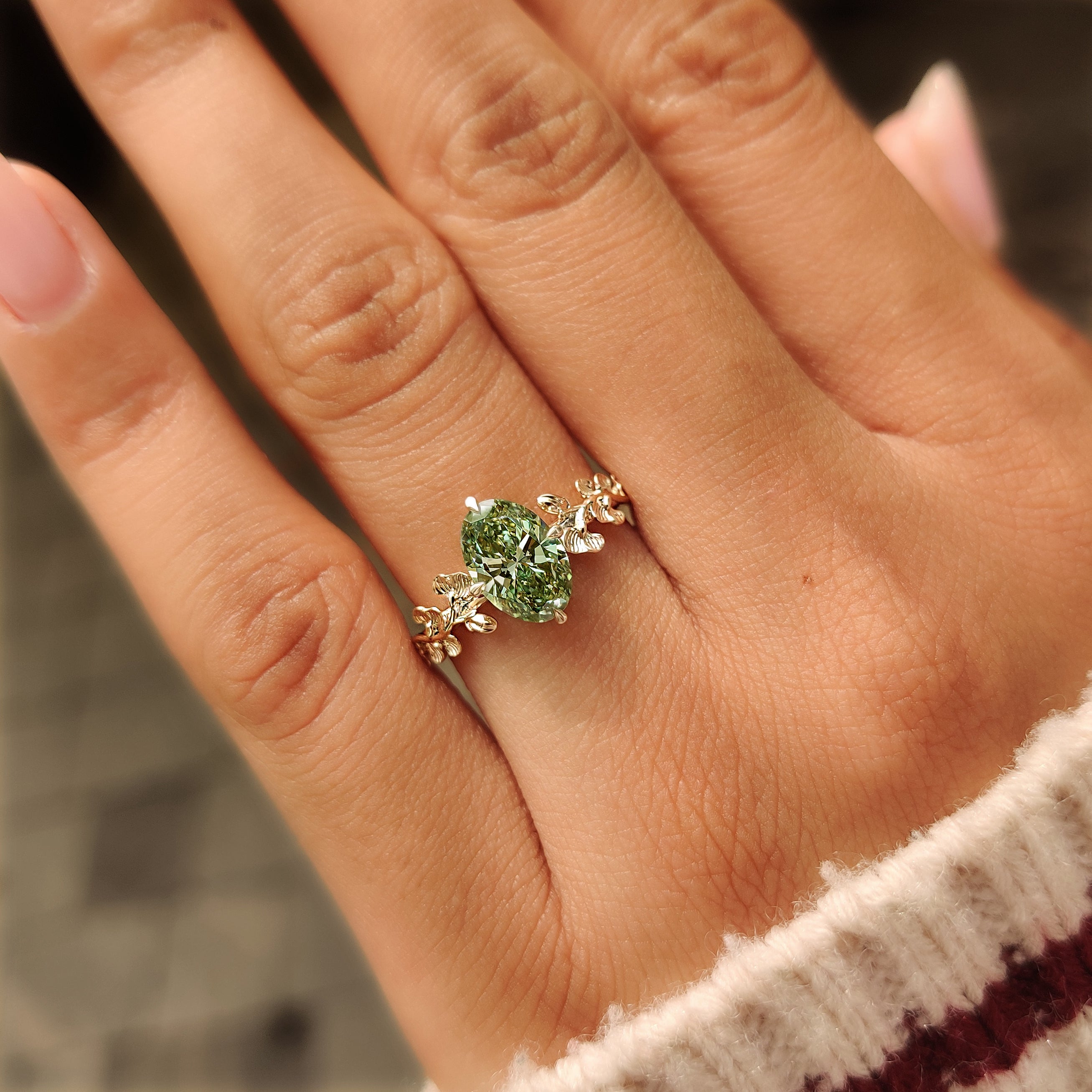 Compass prong setting around a green oval diamond.
