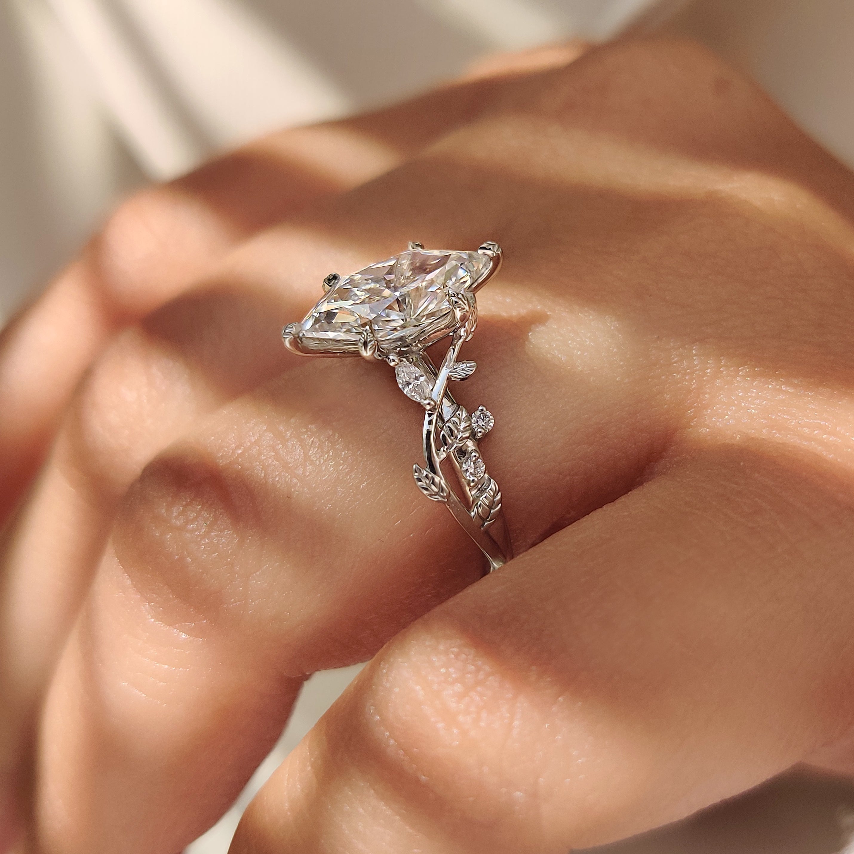 Nature inspired marquise diamond ring with leaf prongs.
