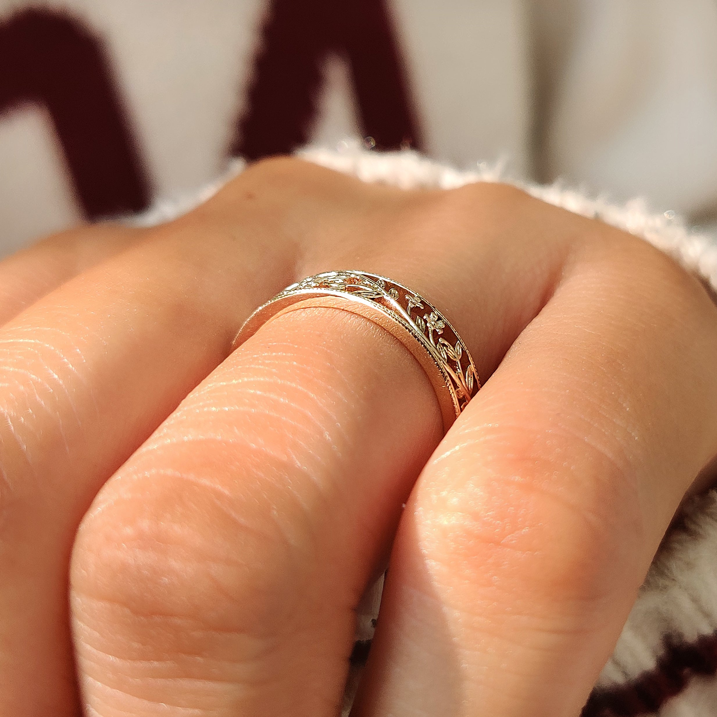 Milgrain details along the edge of a floral wedding band.
