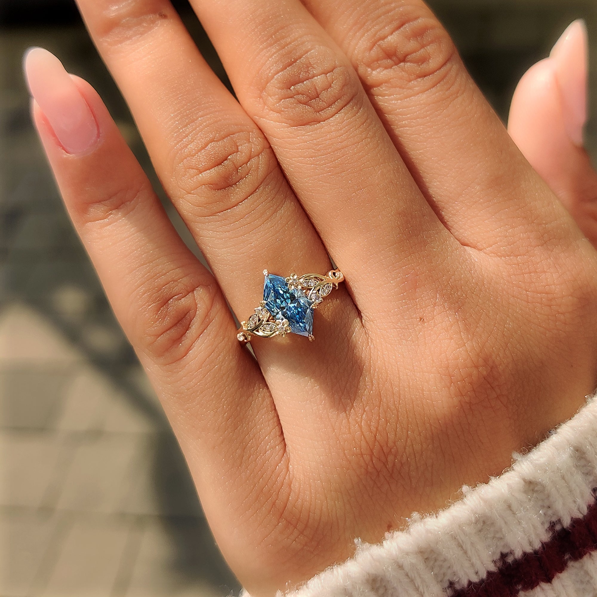 Yellow gold engagement ring with a blue Dutch marquise center.

