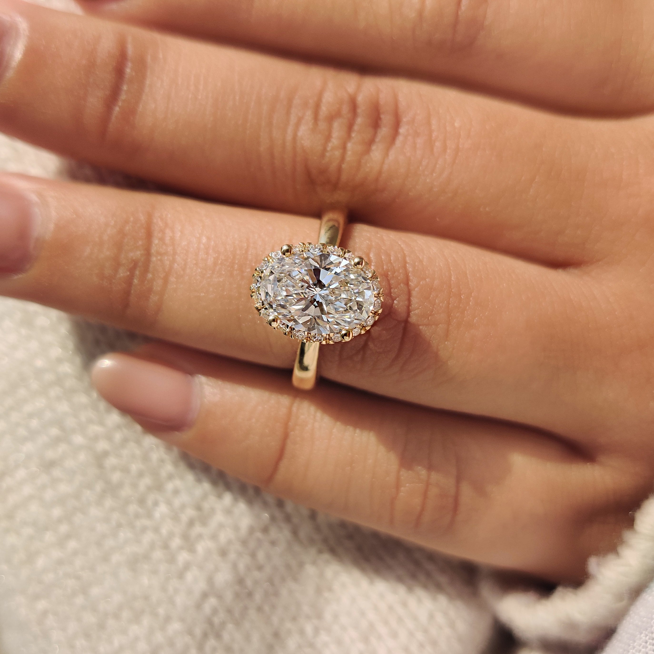 Tapered shank complements oval cut diamond ring with pave band.
