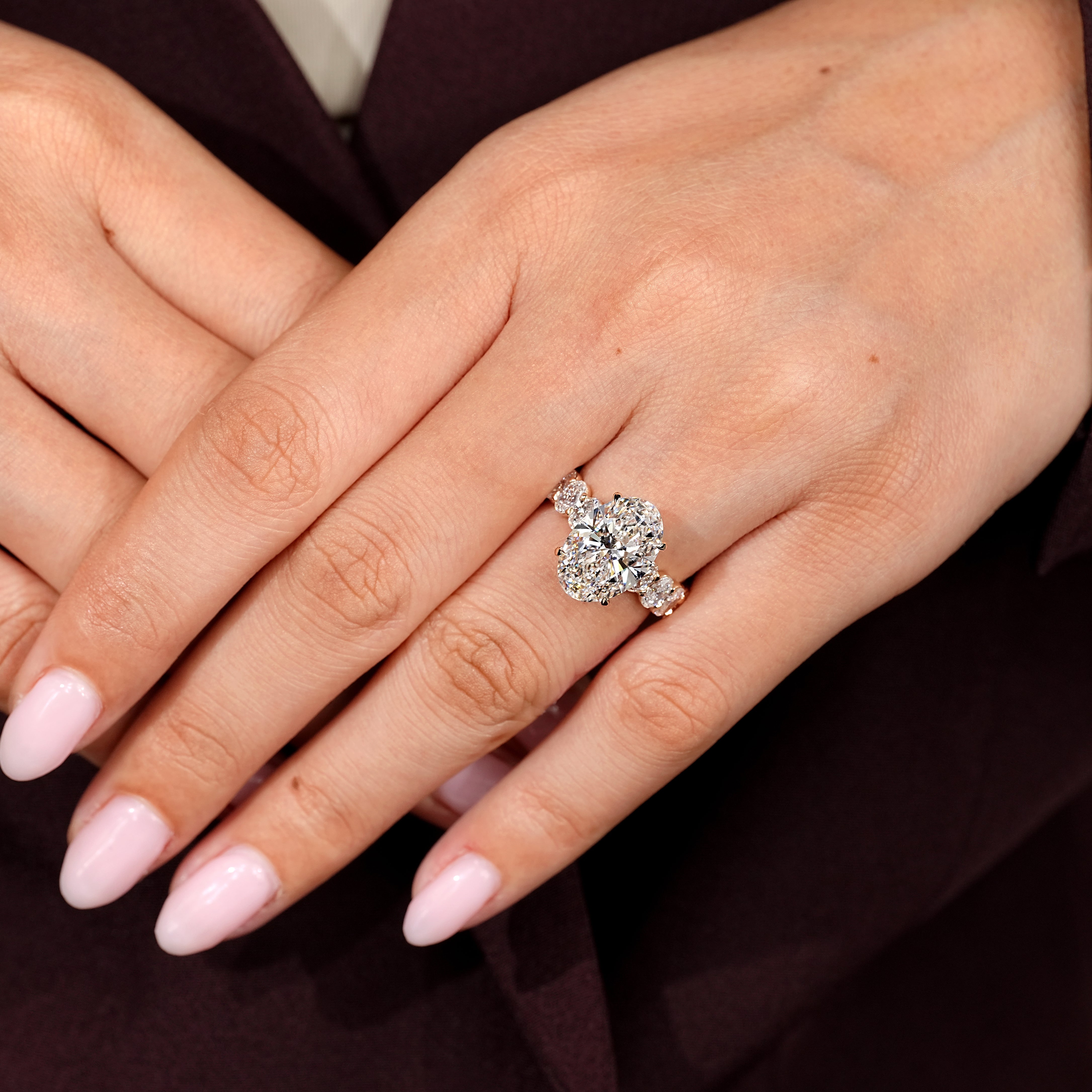 Oval engagement ring with oval side stones and pave setting
