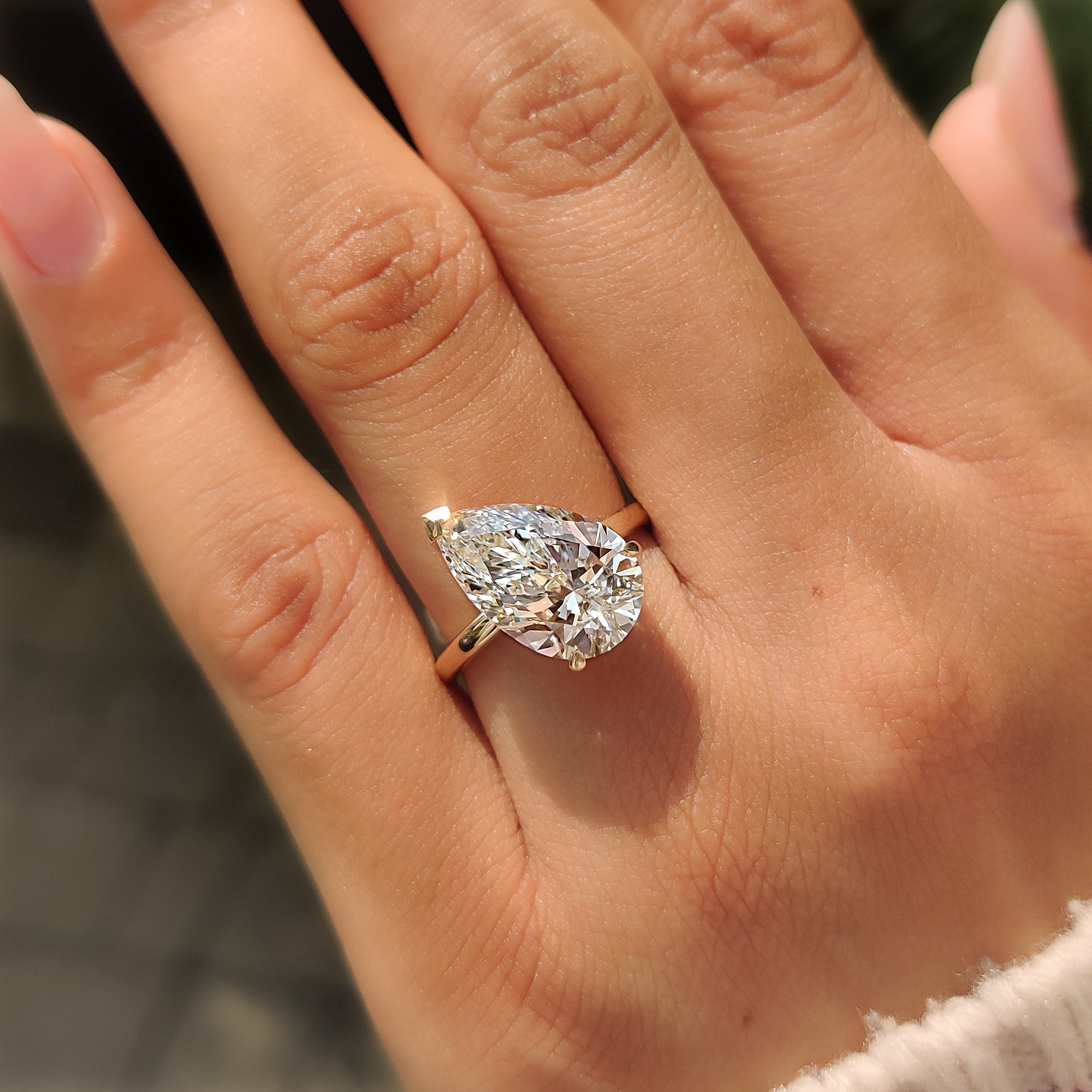 Two claw prongs holding the pear shaped center diamond.
