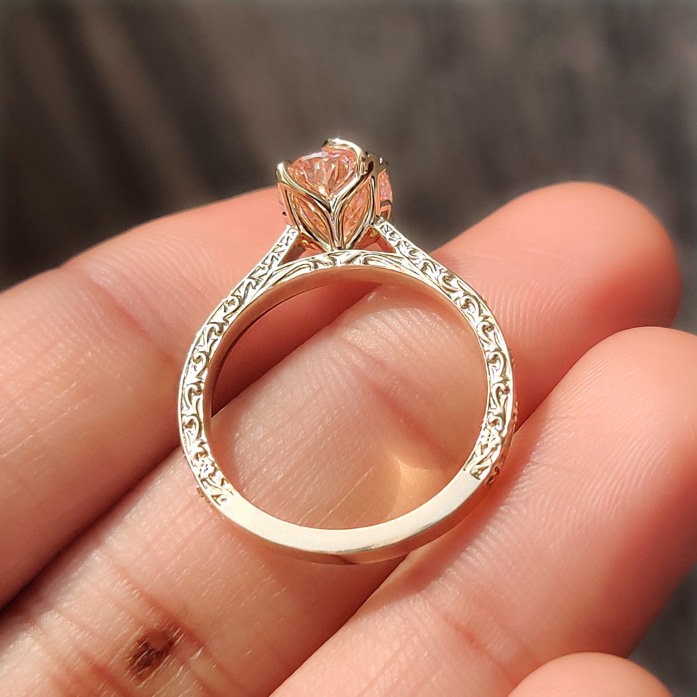 Leaf and floral detail ring with pink oval cut diamond.
