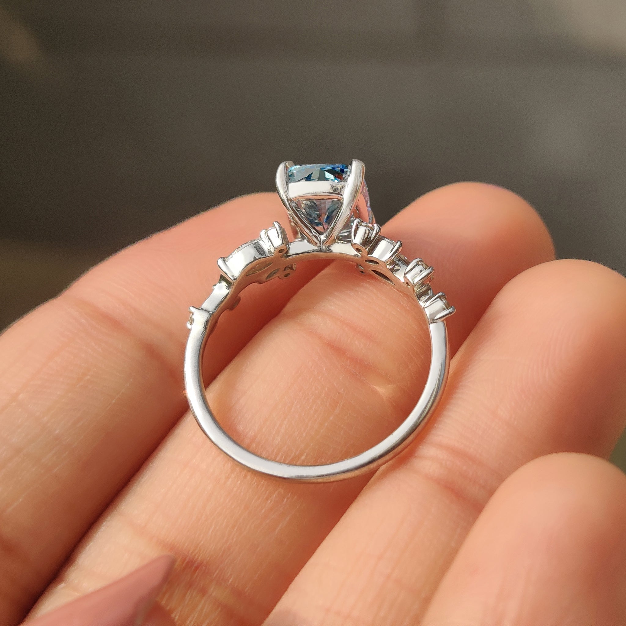 Handmade blue cushion cut diamond ring with cluster setting.
