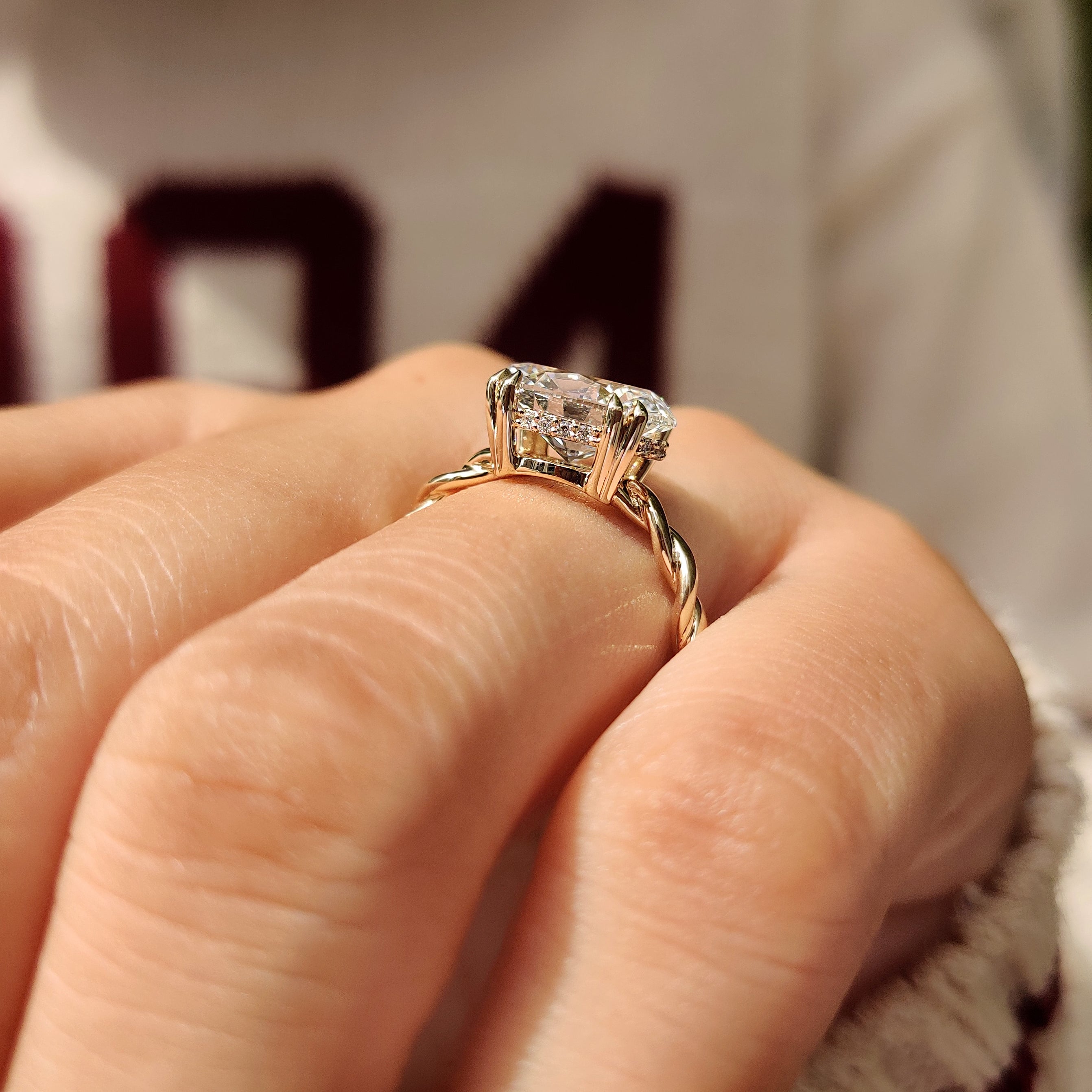 Twisted shank oval diamond ring with hidden halo details
