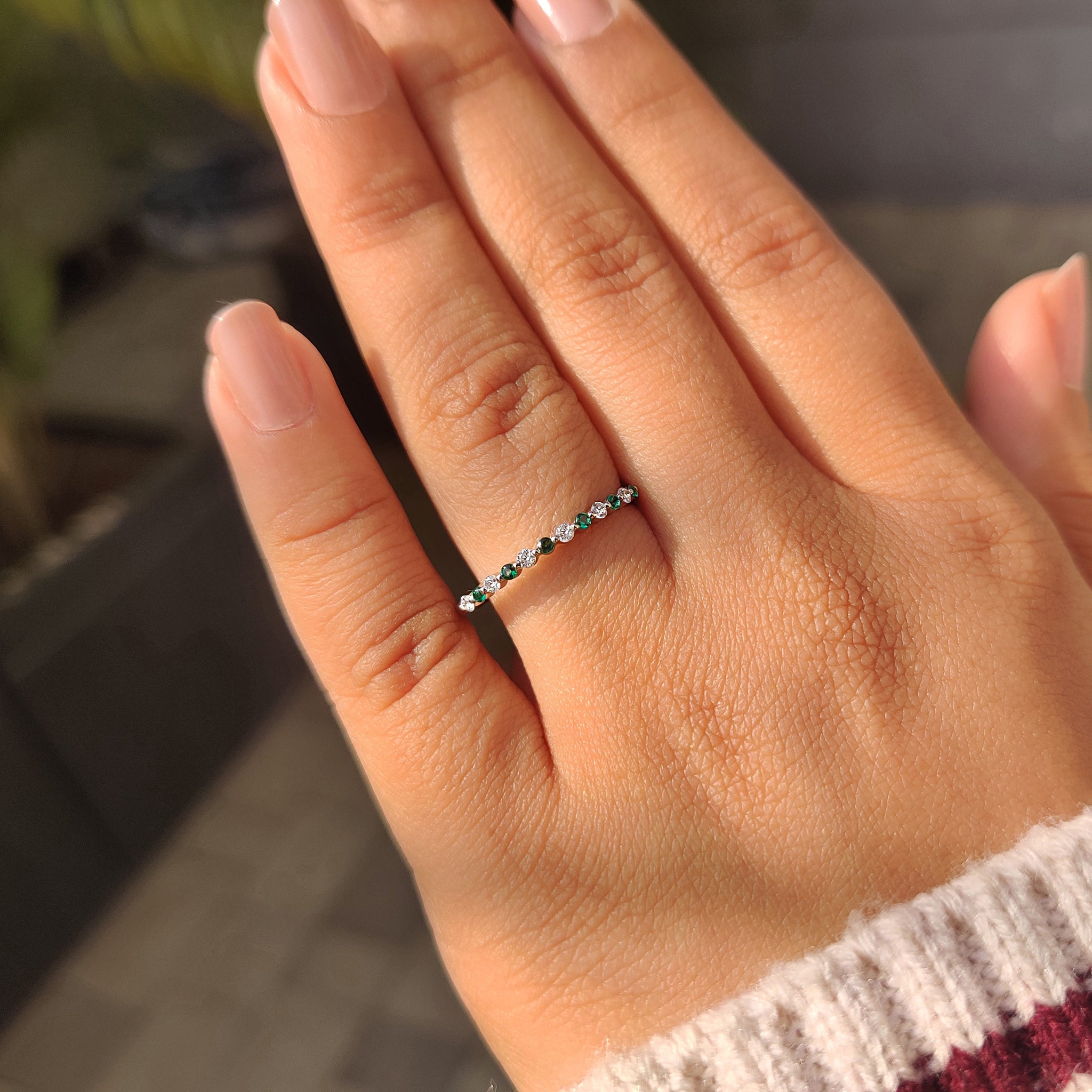 Shared prong diamond and emerald gemstone half eternity style.
