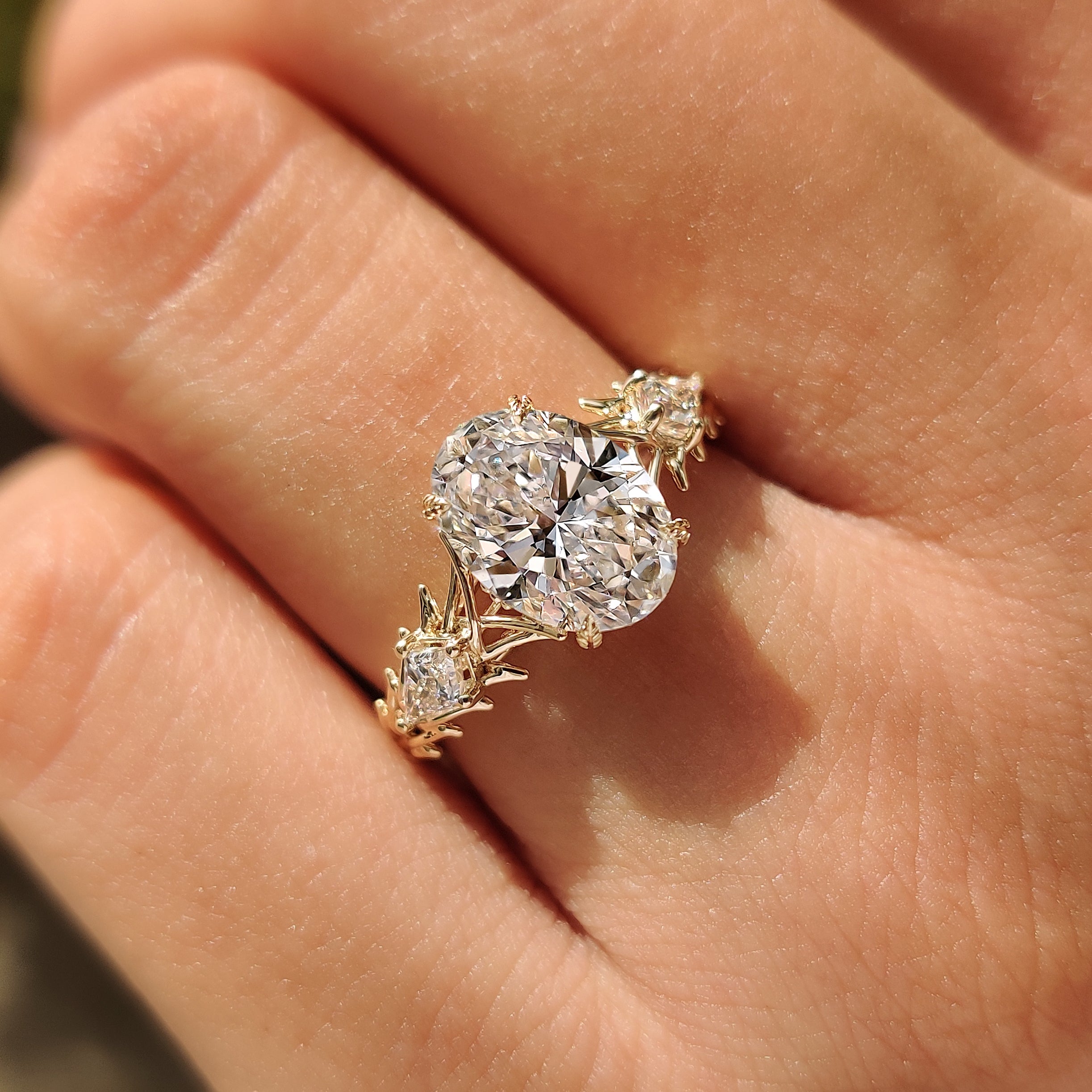 Oval Three Stone Ring with Kite Side Stones and Thorn Style Setting