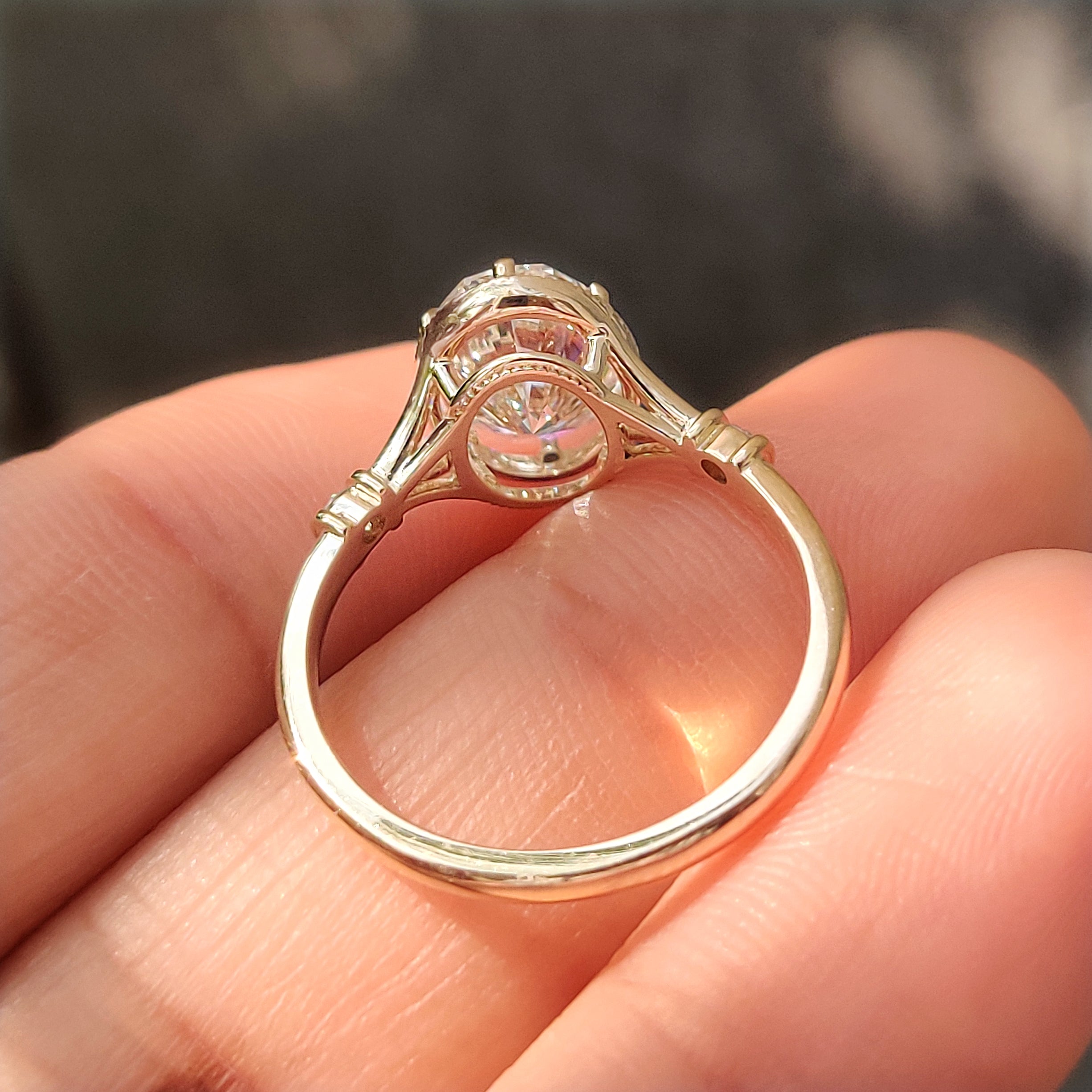 Bezel style engagement ring with oval and round diamonds.
