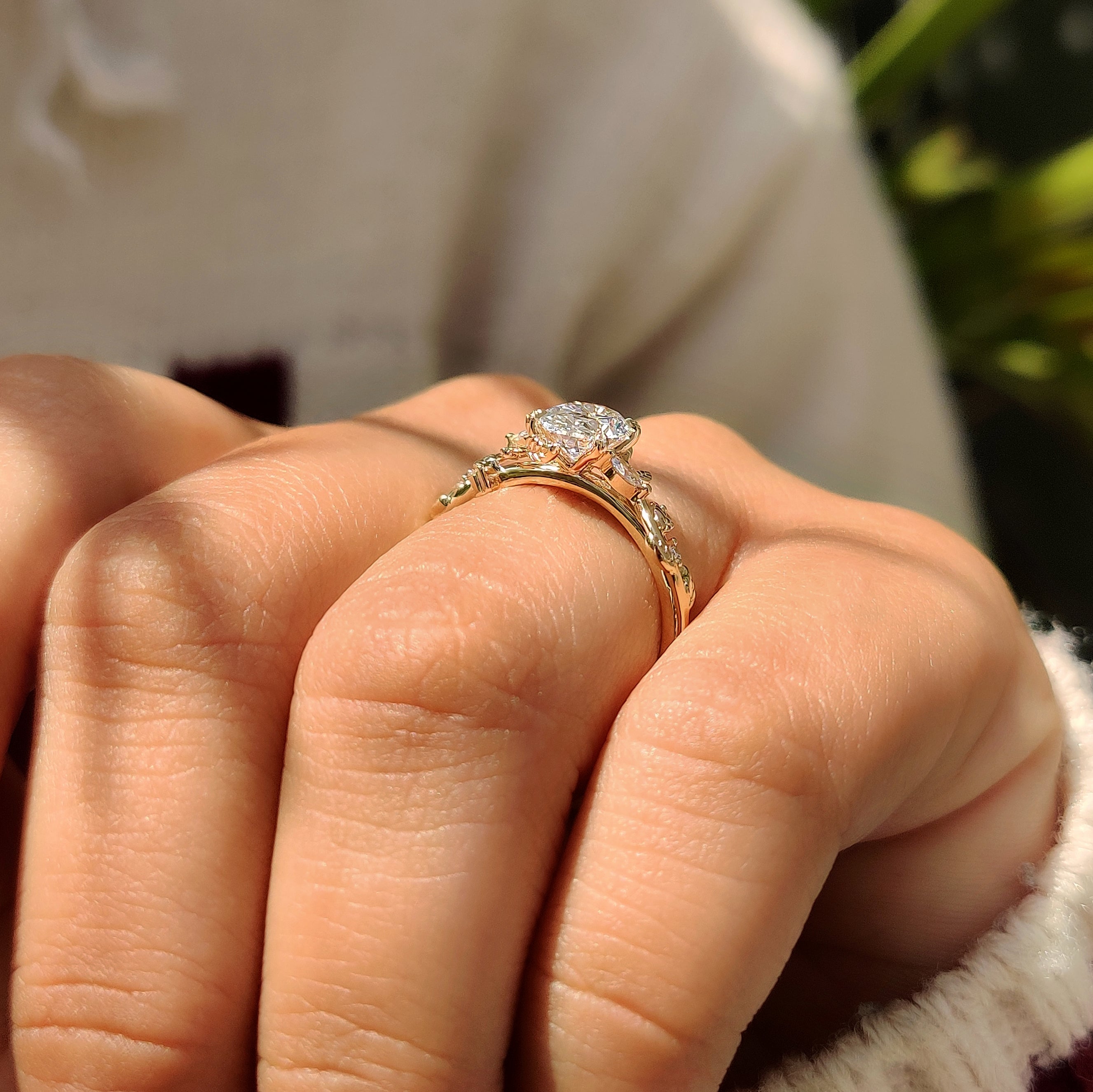 Oval diamond ring with marquise accents and vine details.

