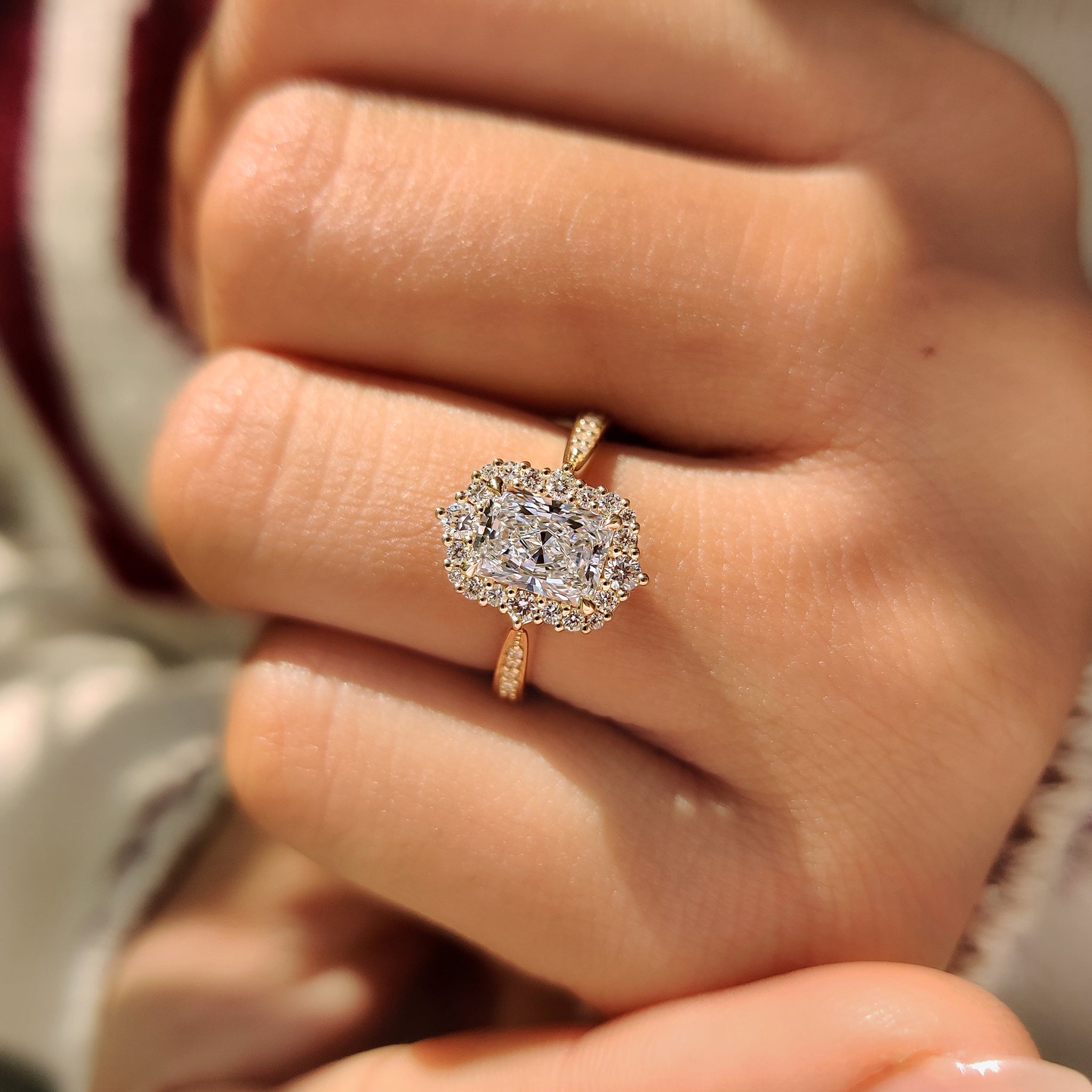 Radiant halo ring with tapered shank and pave diamonds.
