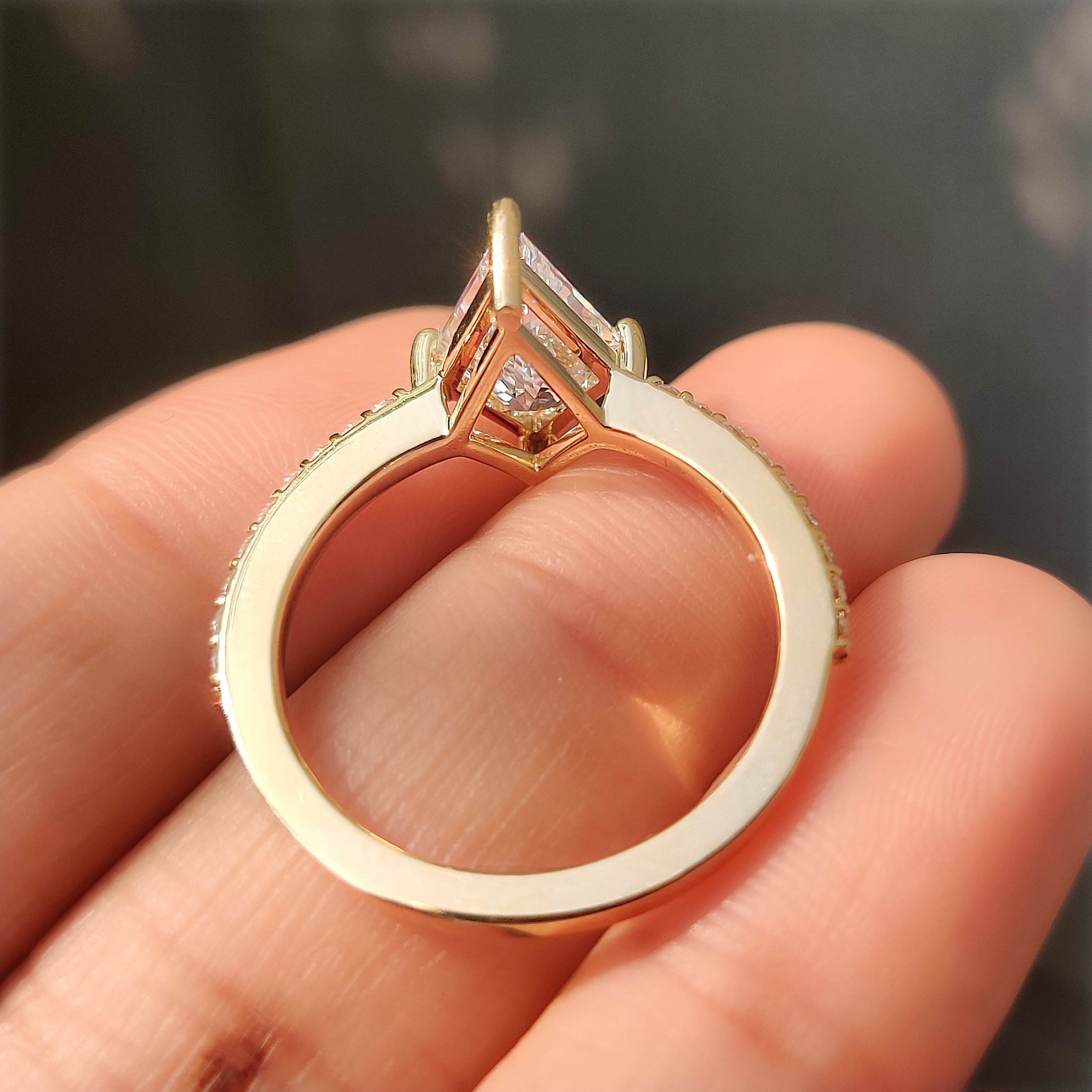 Lab grown kite cut diamond engagement ring with round accents.
