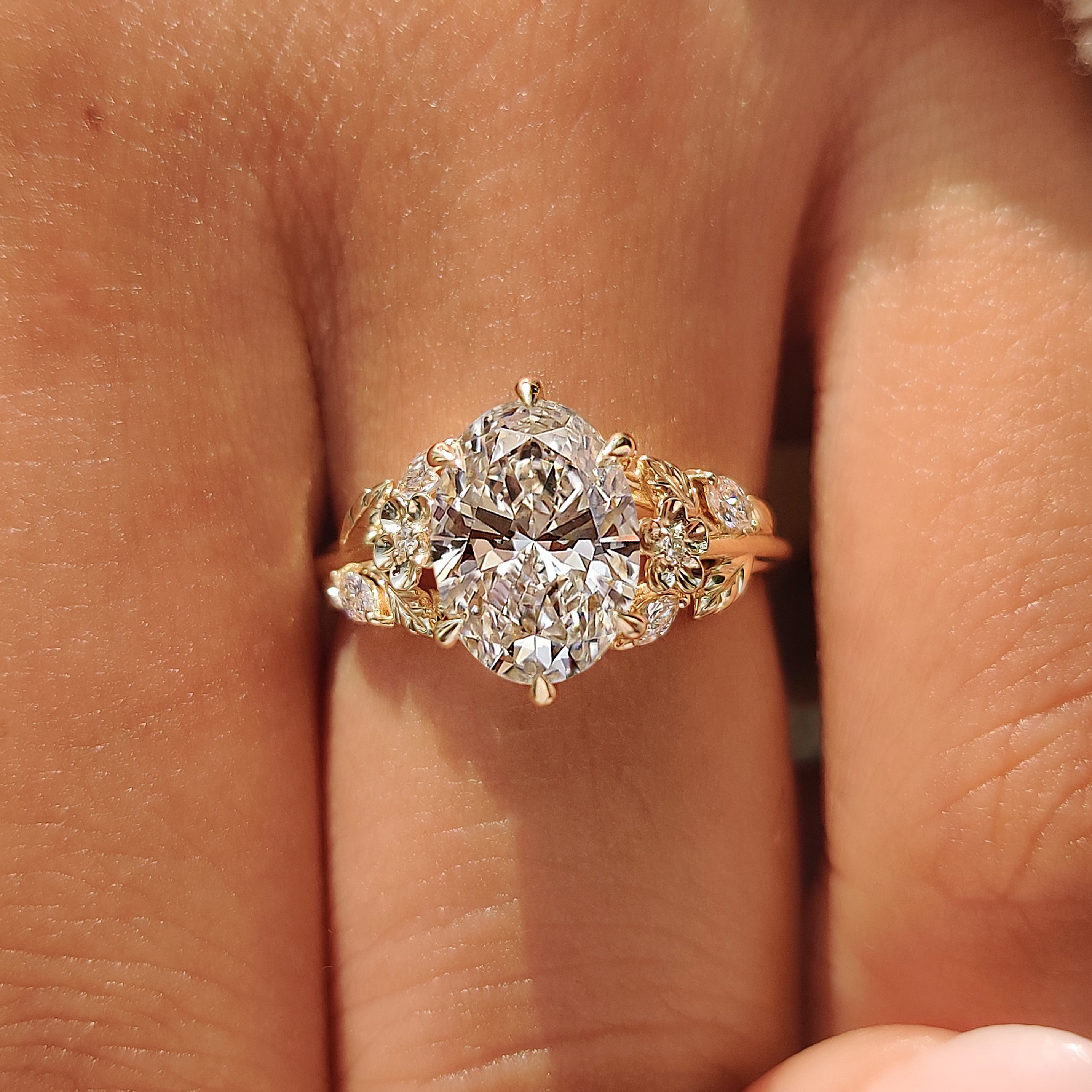 Oval diamond ring with marquise and round side stones.
