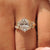 Oval diamond ring with marquise and round side stones.
