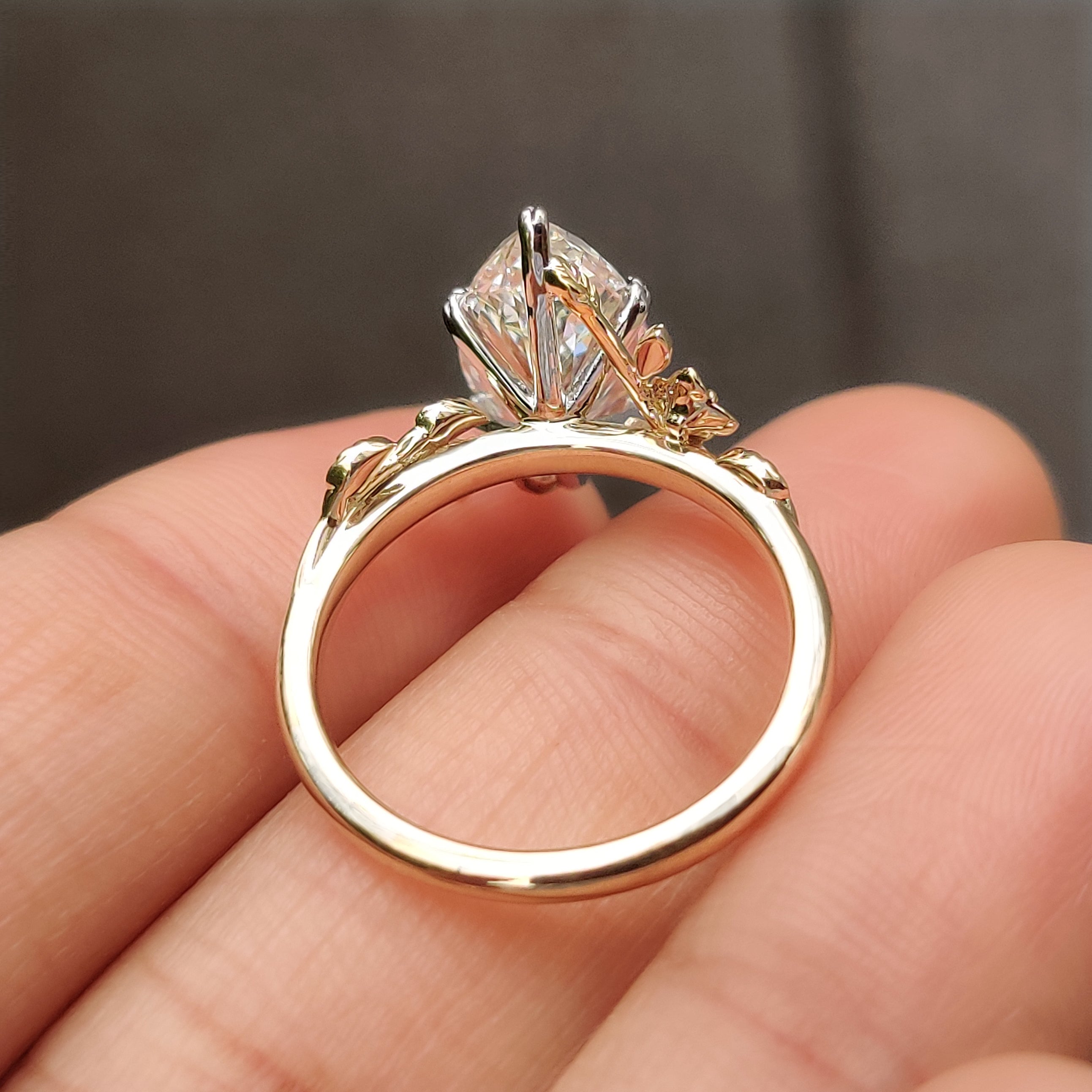 Engagement ring with leaf style shank and round side stones
