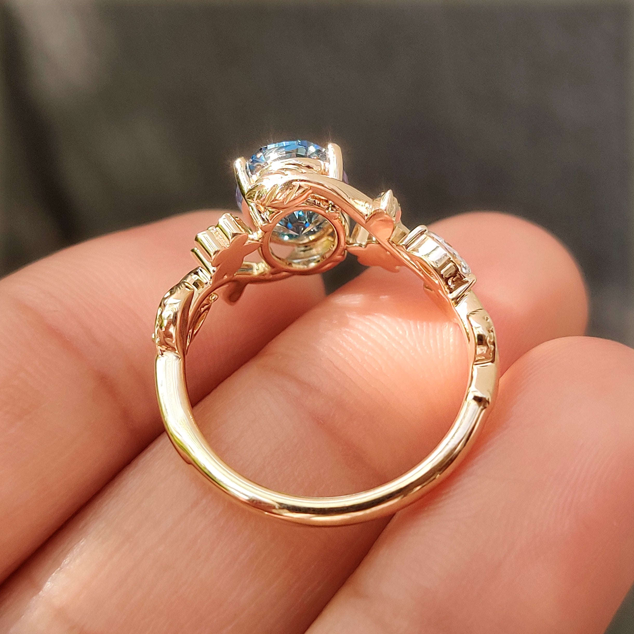 Four claw prong setting on green oval solitaire ring.
