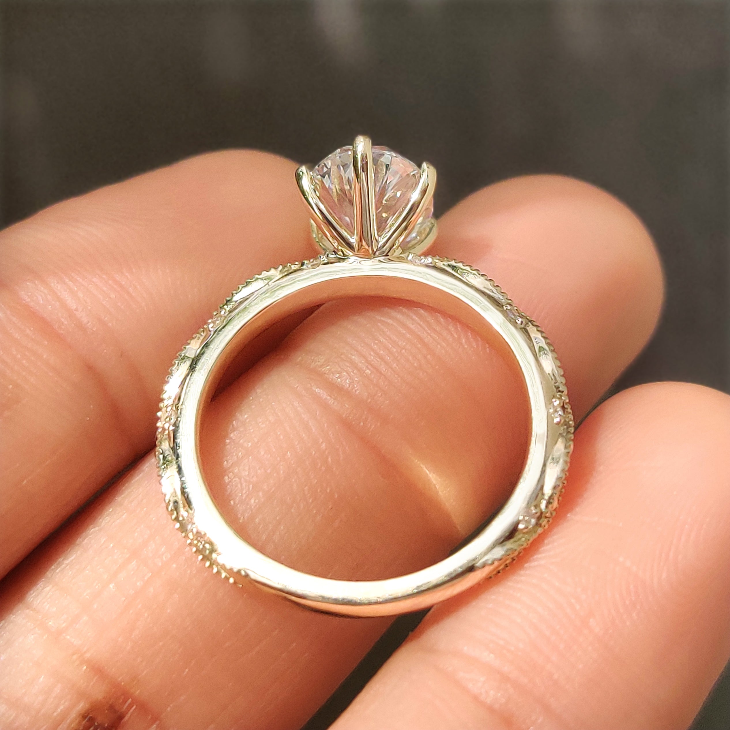 Oval center stone with six claw prong setting and side stones

