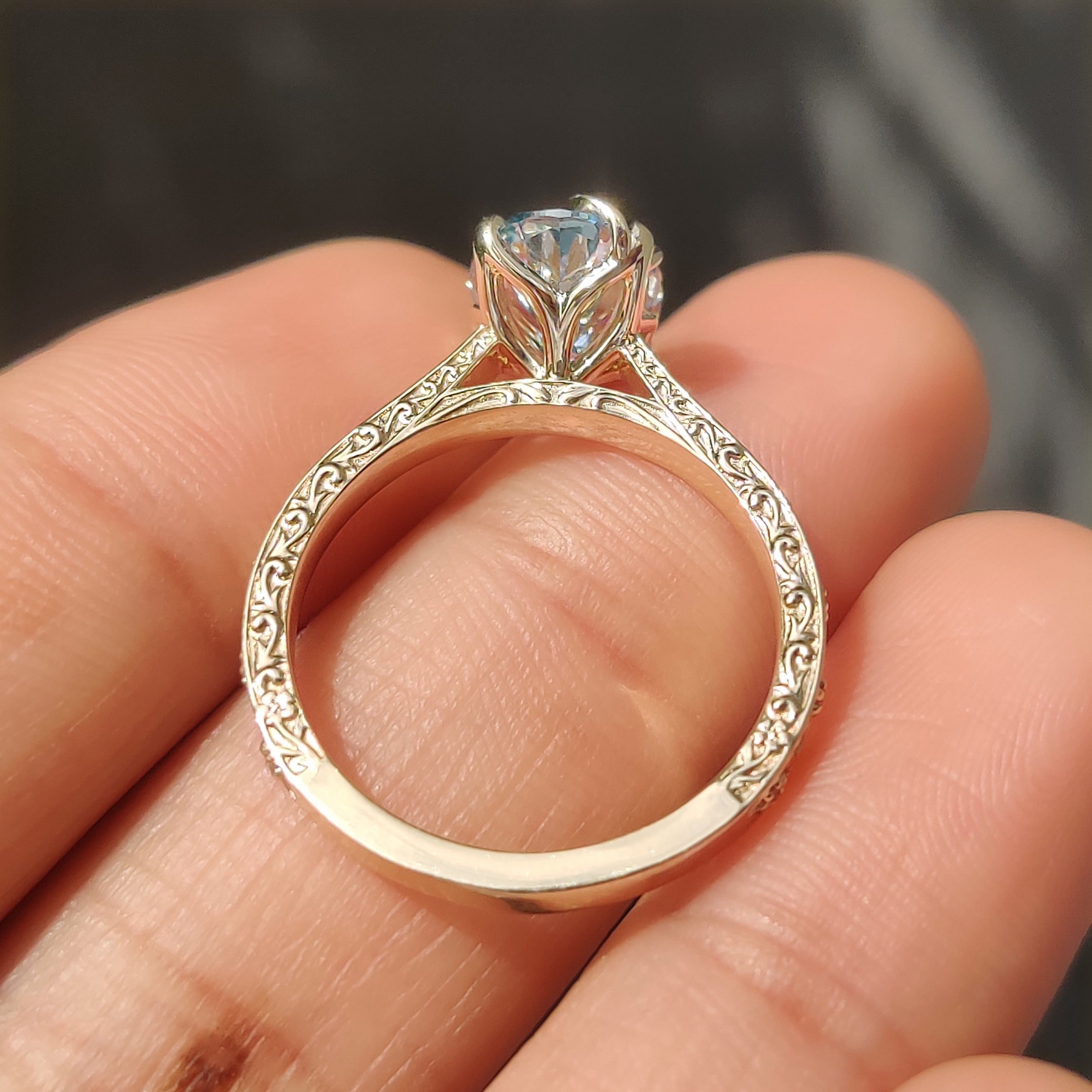 Blue oval diamond ring in tulip setting with claw prongs
