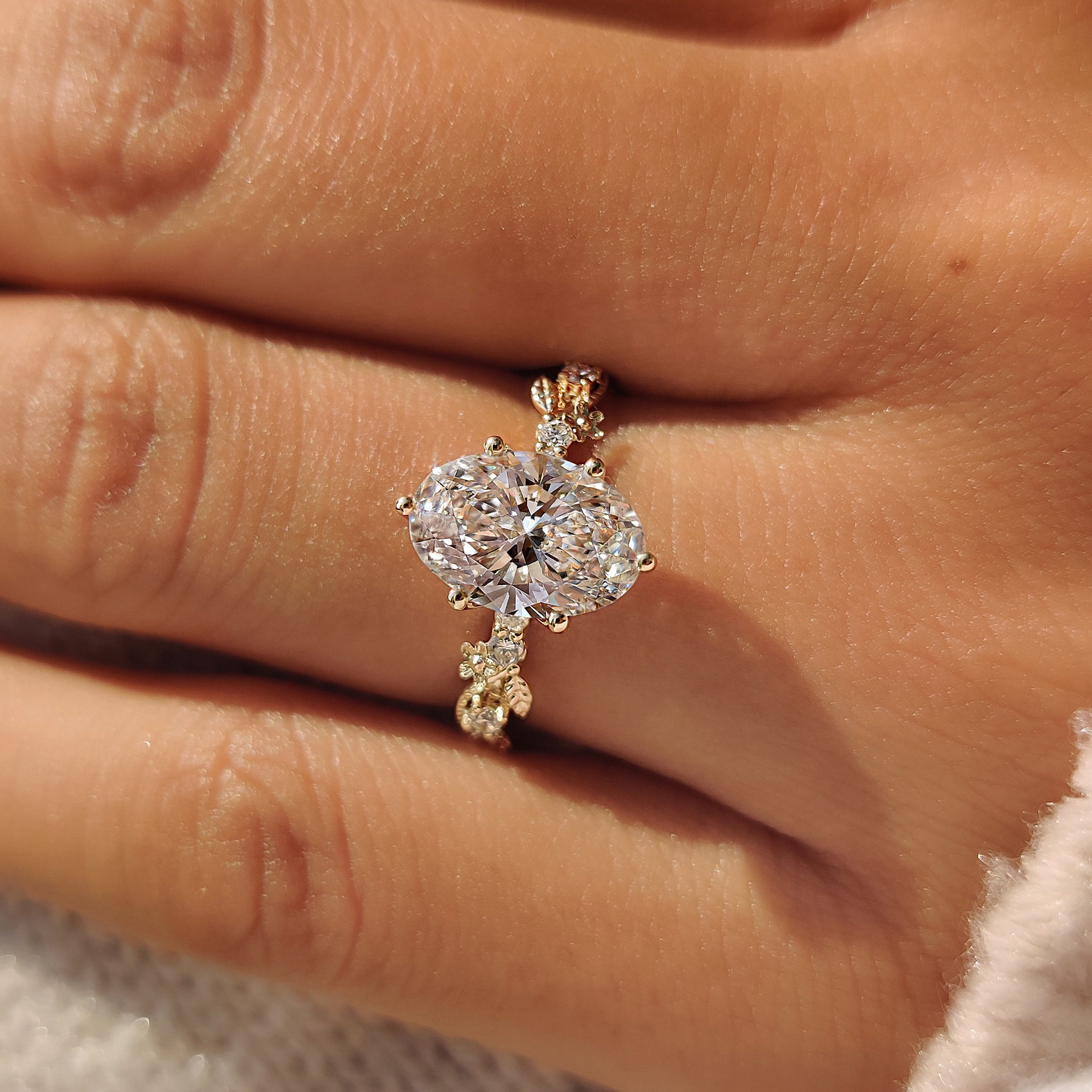 Round side stones beside an oval center diamond.
