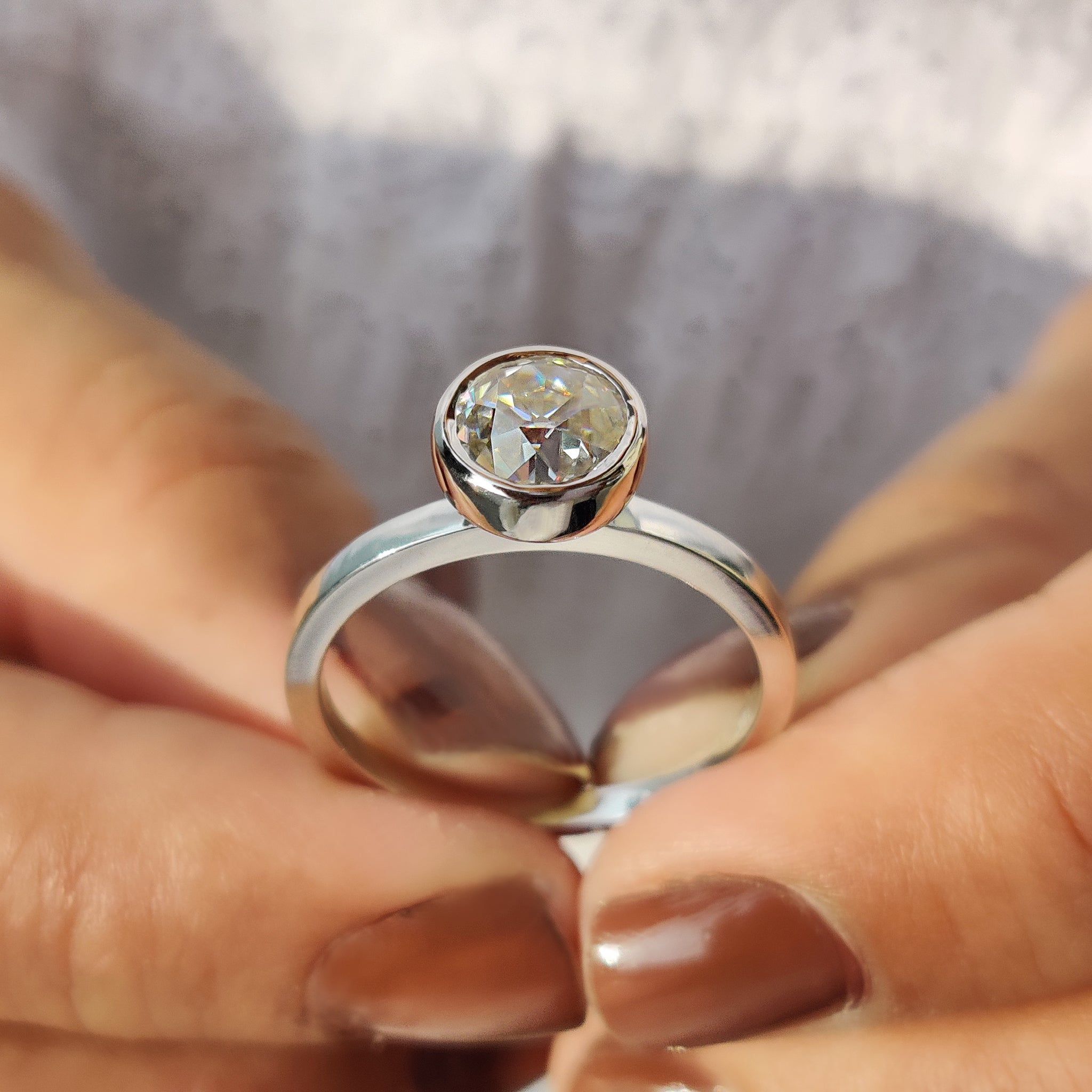 White gold solitaire ring with round moissanite.
