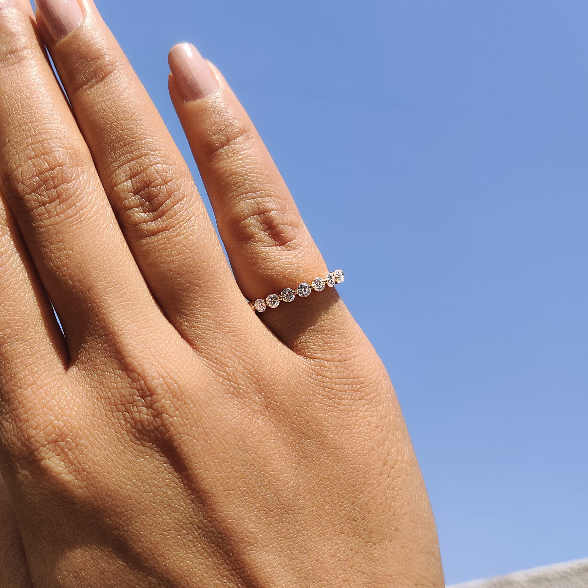 Custom wedding band made with round cut moissanite stones in yellow gold.