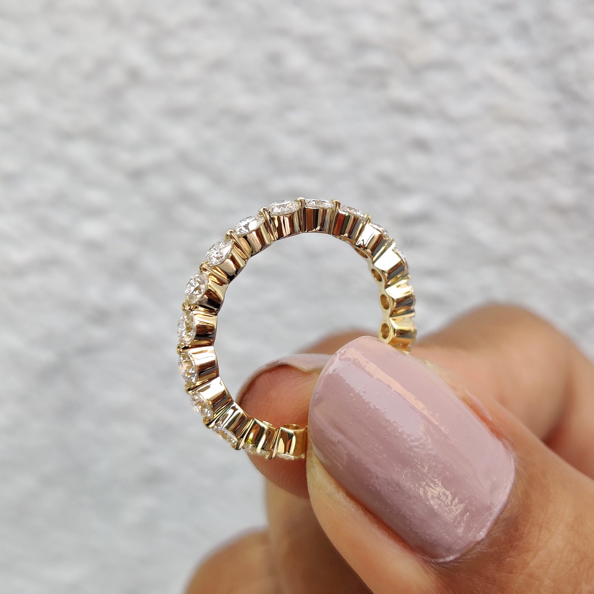 Buy moissanite band online, featuring round cut stones in a floating design.