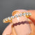 Moissanite wedding band with prong set design in elegant yellow gold.