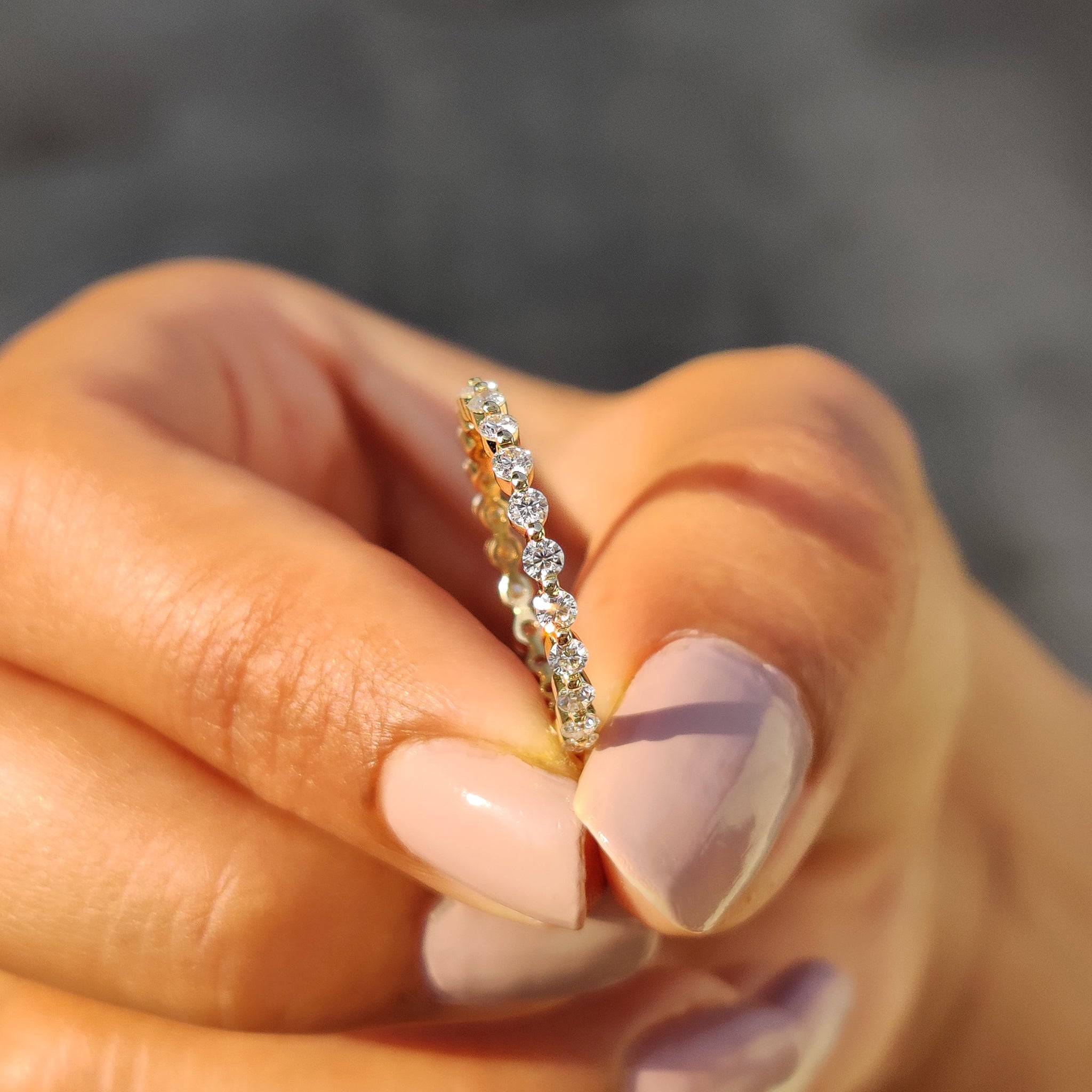 Yellow gold eternity band featuring stunning round Moissanite stones.