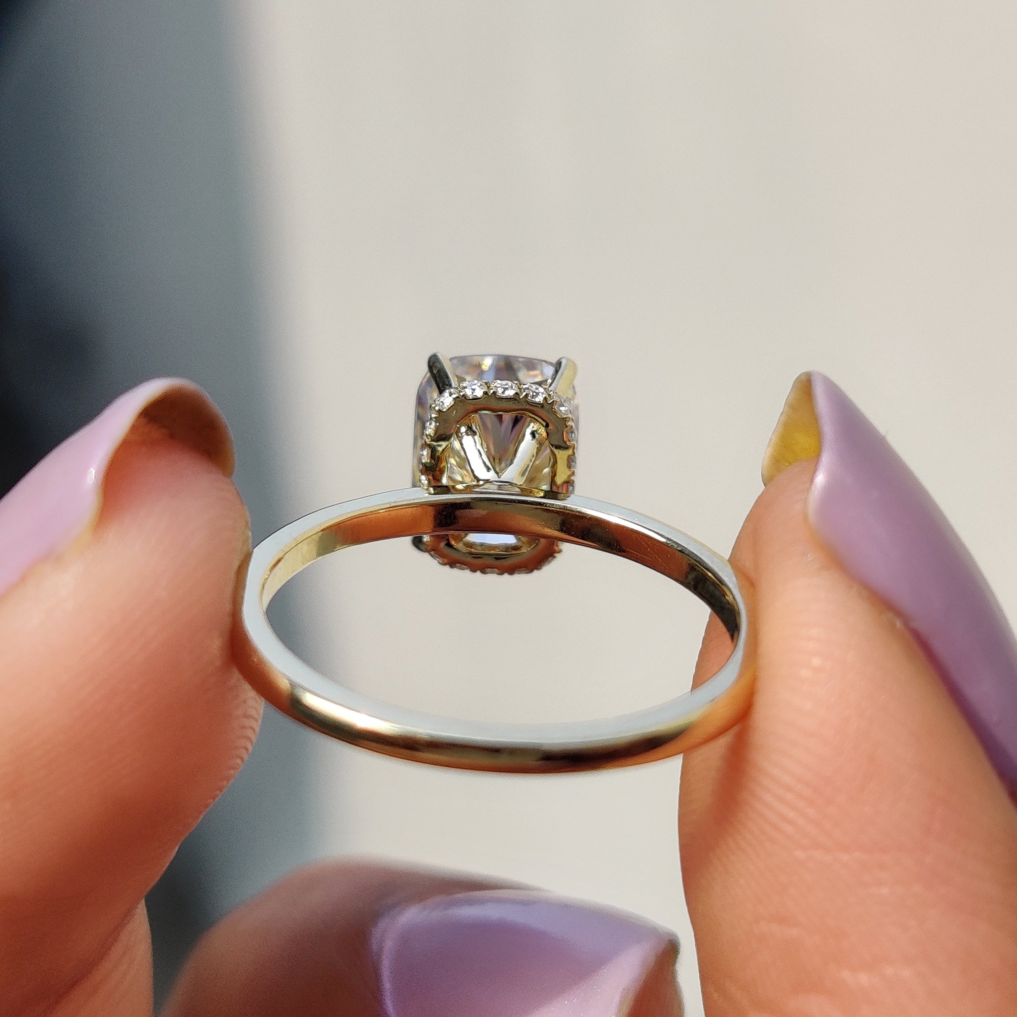 Prong setting ring featuring cushion cut moissanite.