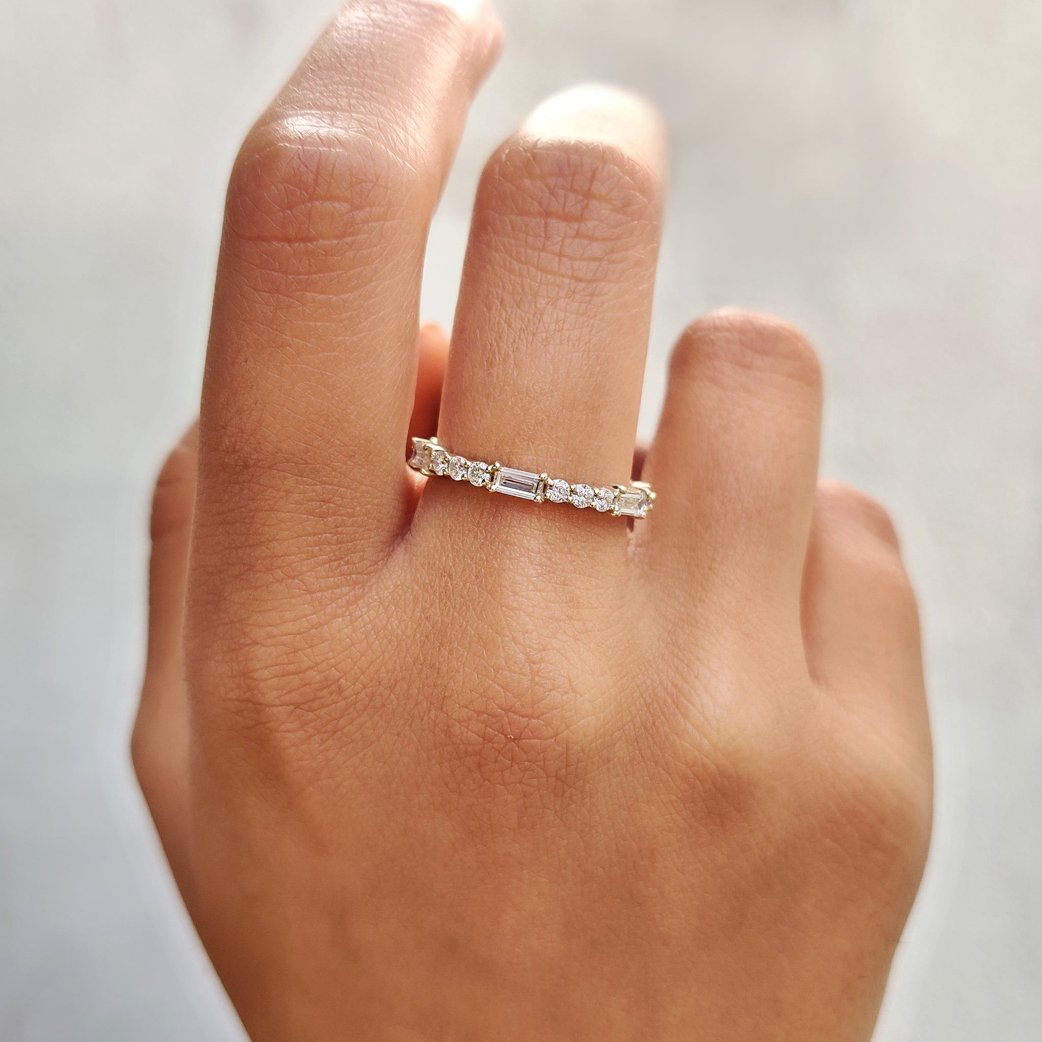Full eternity wedding band featuring a yellow gold moissanite band.