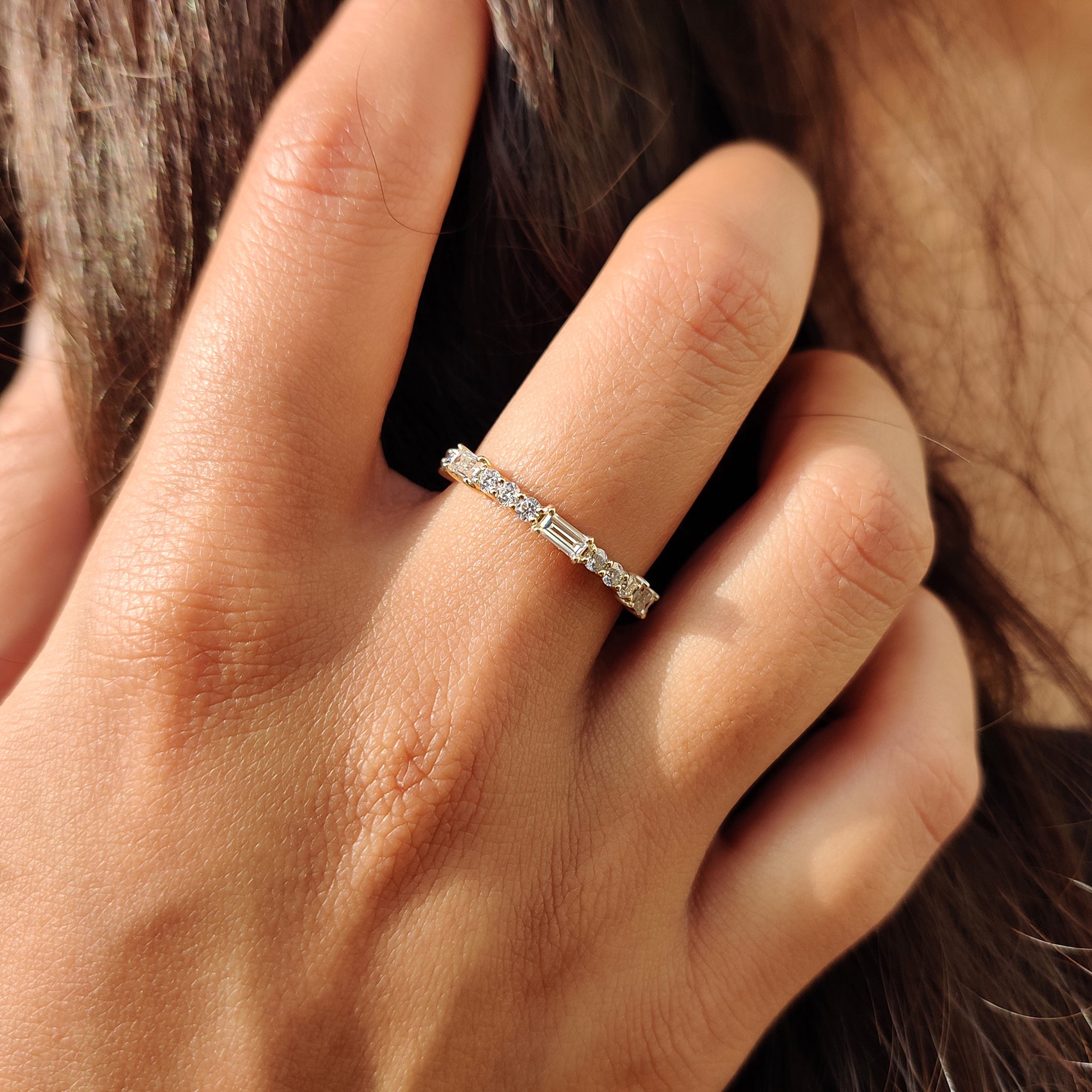 Prong set wedding band with a round and baguette moissanite eternity band.