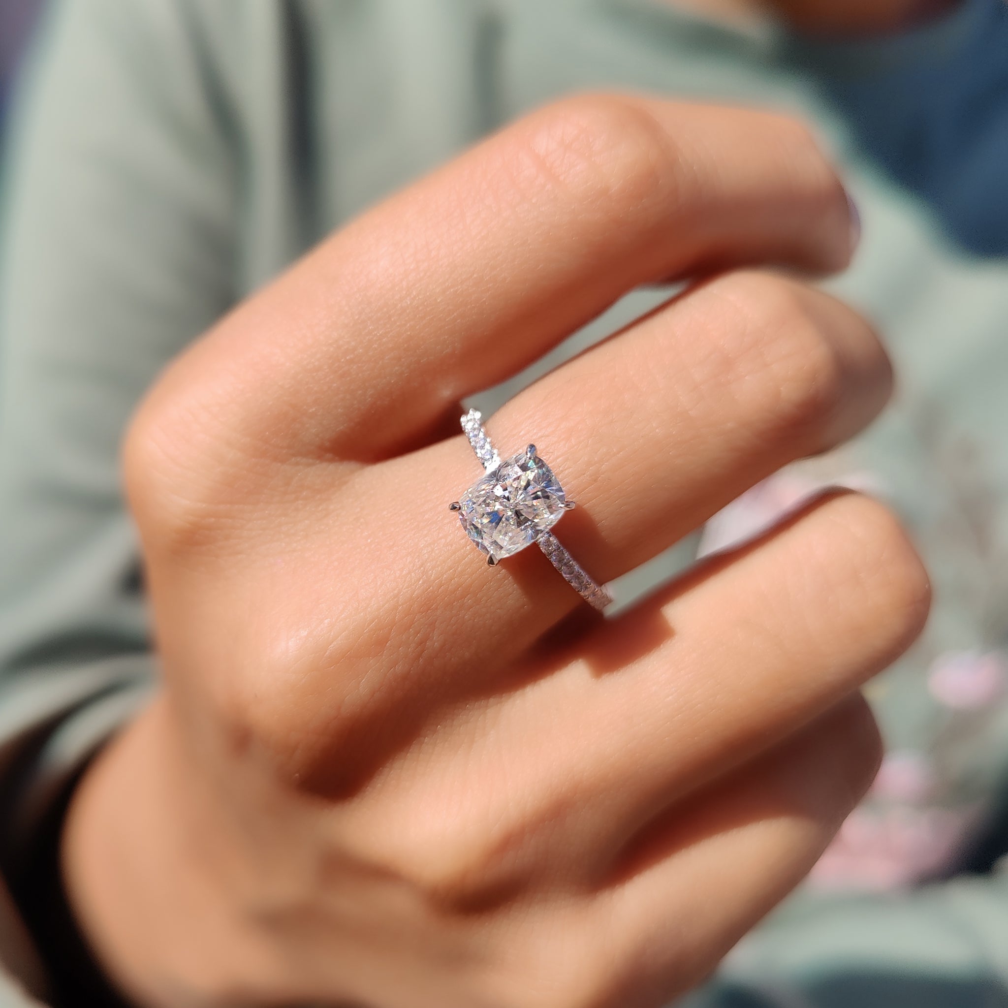 Cushion cut pave engagement ring with round accents.