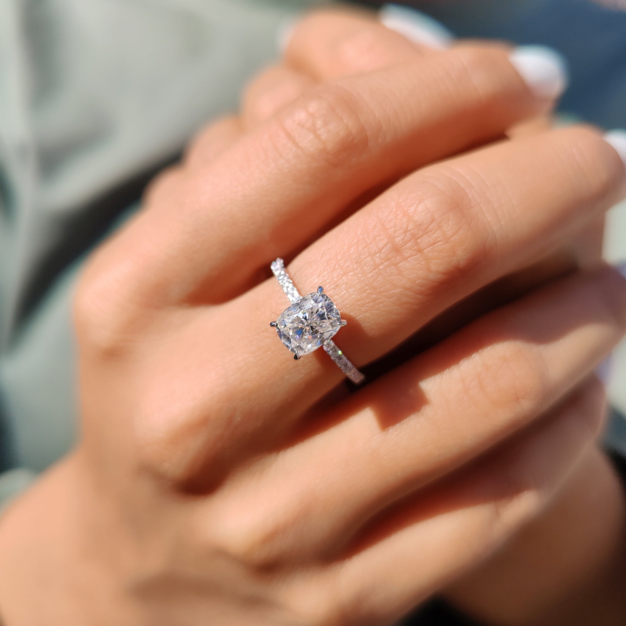 White gold engagement ring with cushion and pave layout.