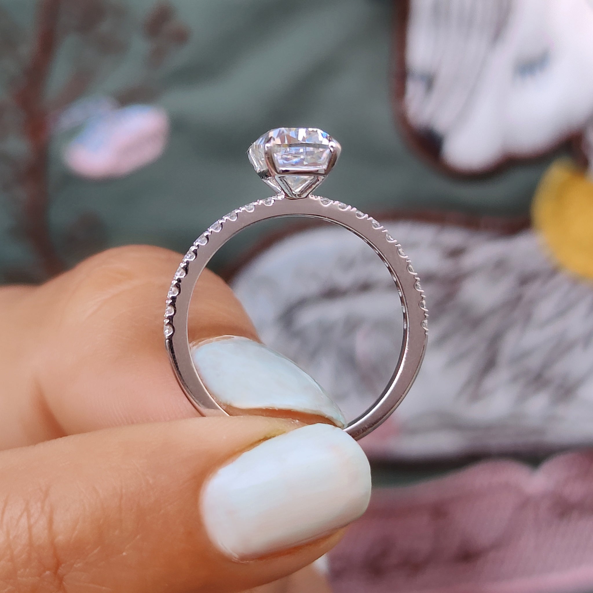 Cushion with round pave set ring in prong setting.