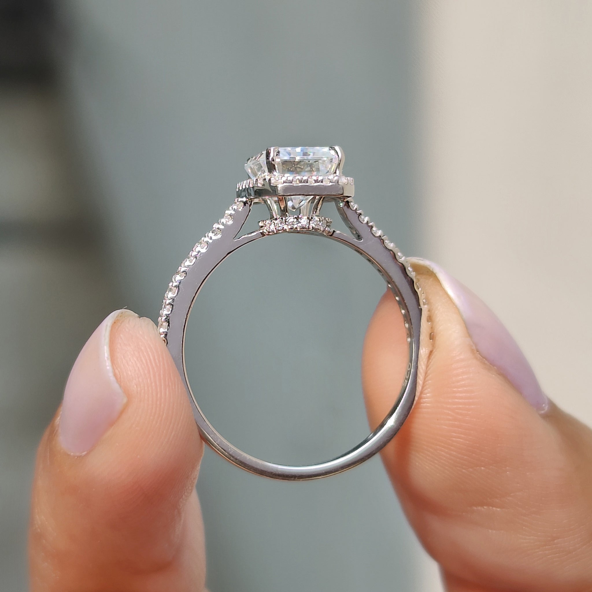 White gold radiant cut moissanite ring with a delicate pave band.