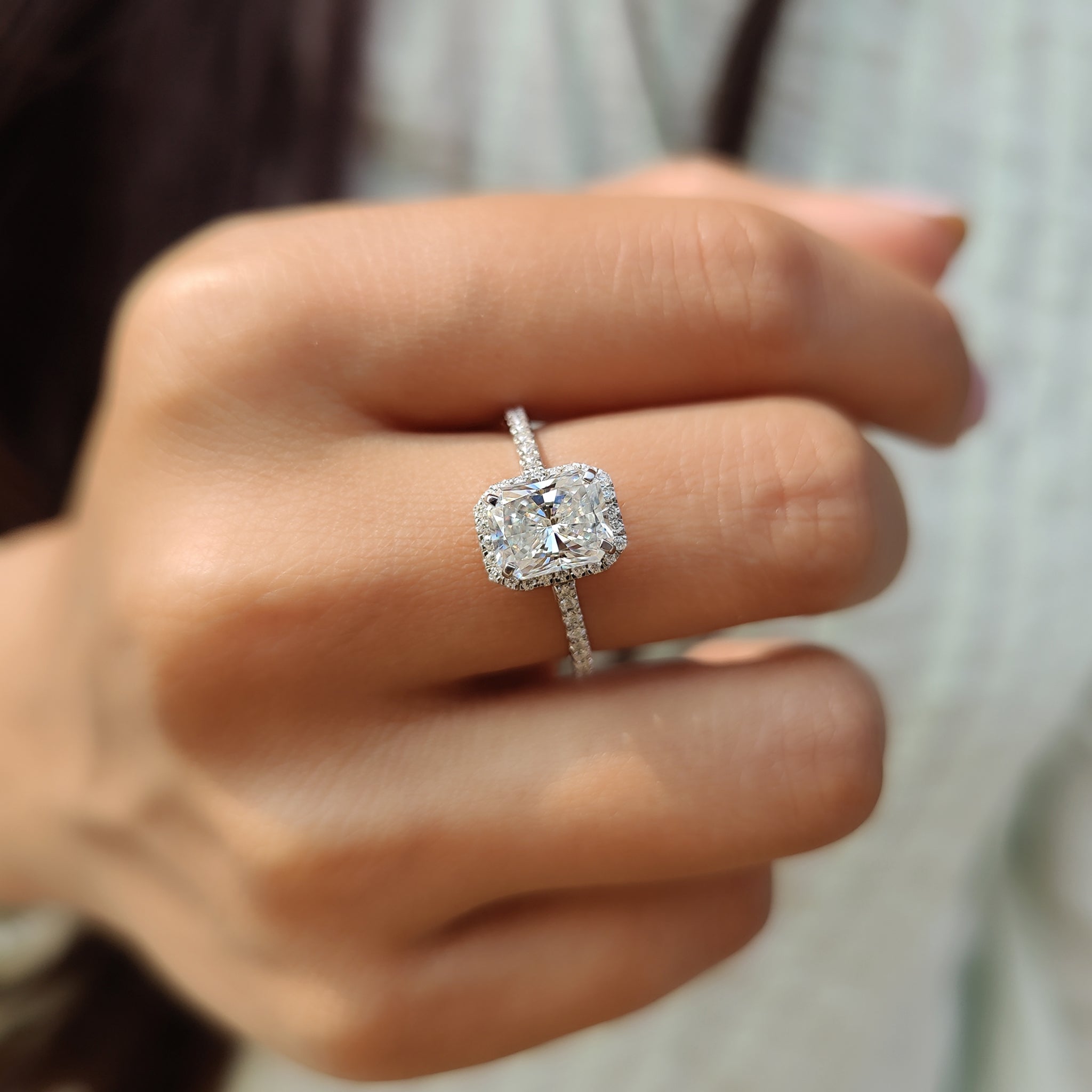 Moissanite radiant cut ring with a white gold pave round cut band.