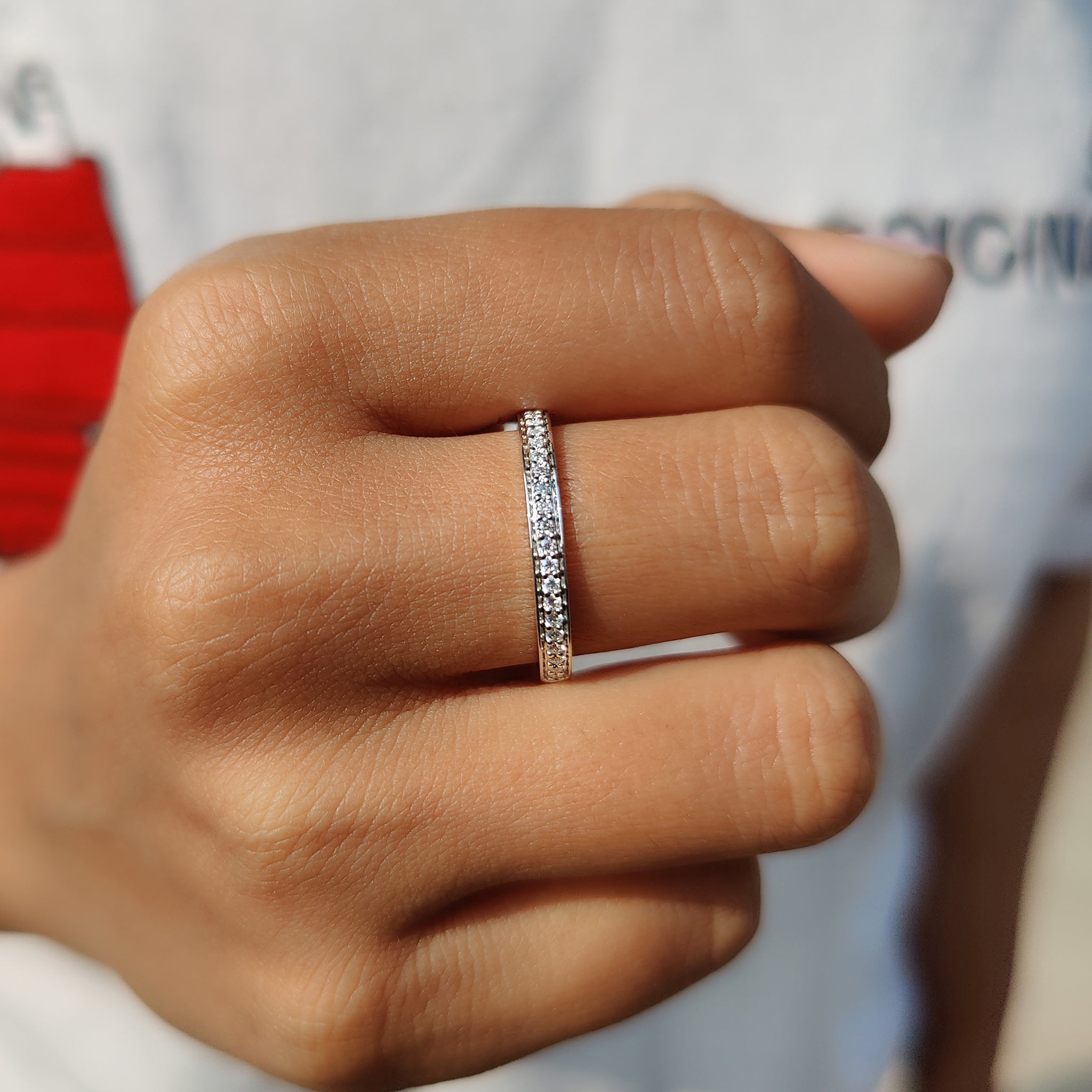 Half eternity wedding band with a sleek round moissanite setting.