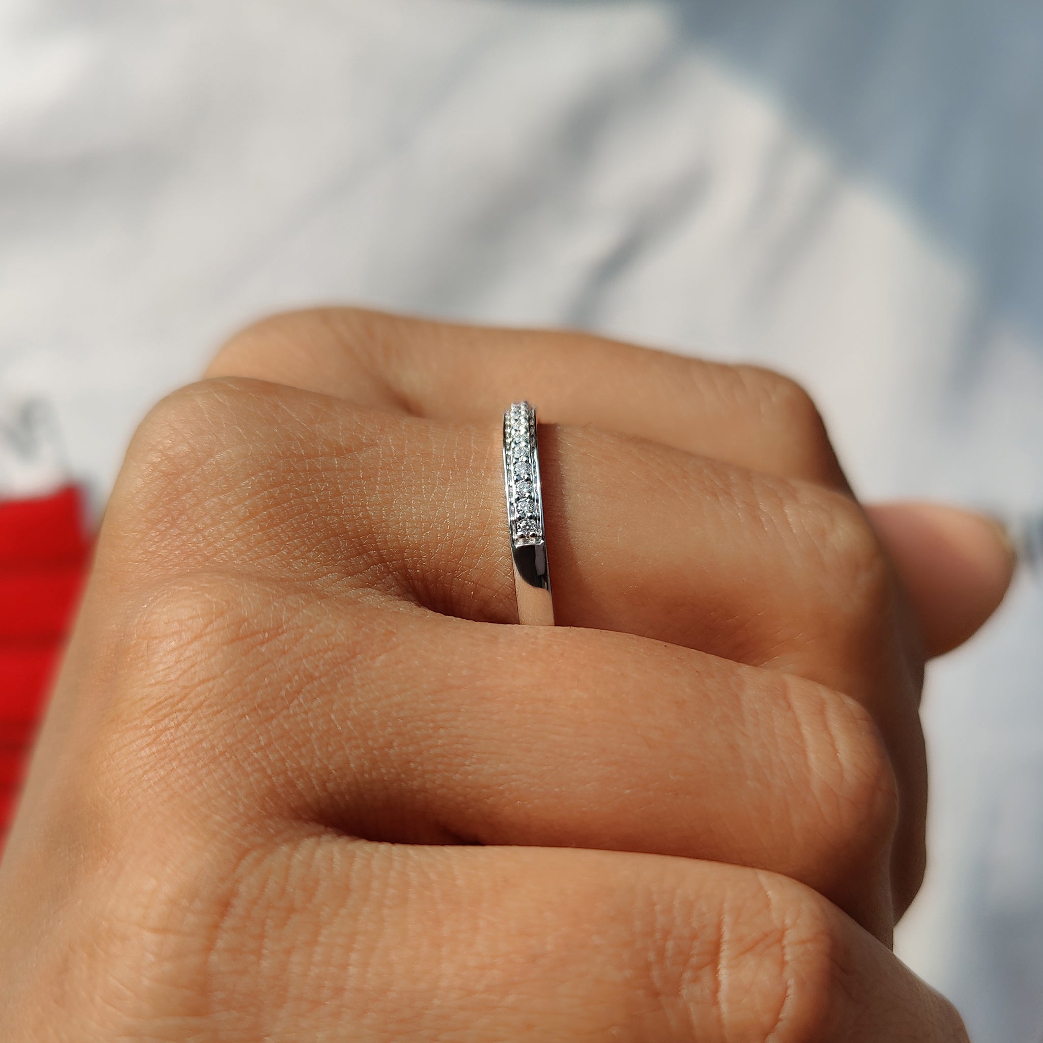 Prong set wedding band made with moissanite stones in white gold.