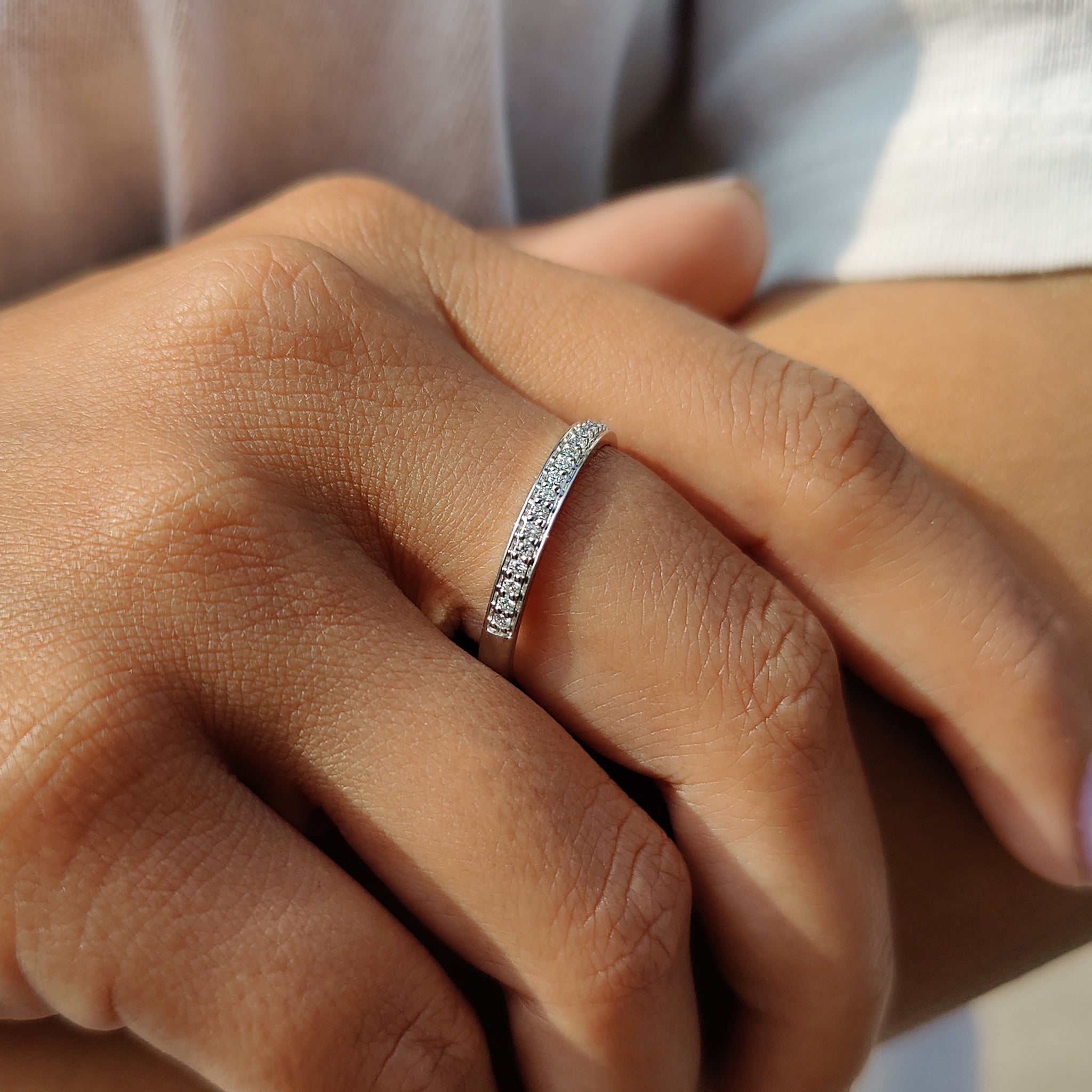 Simple wedding band in white gold with round moissanite accents.