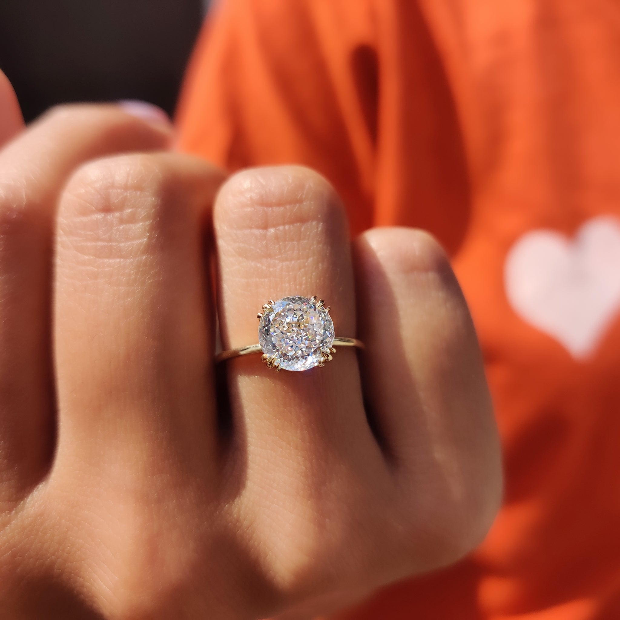 Claw prong ring setting securing a moissanite gemstone on a smooth band
