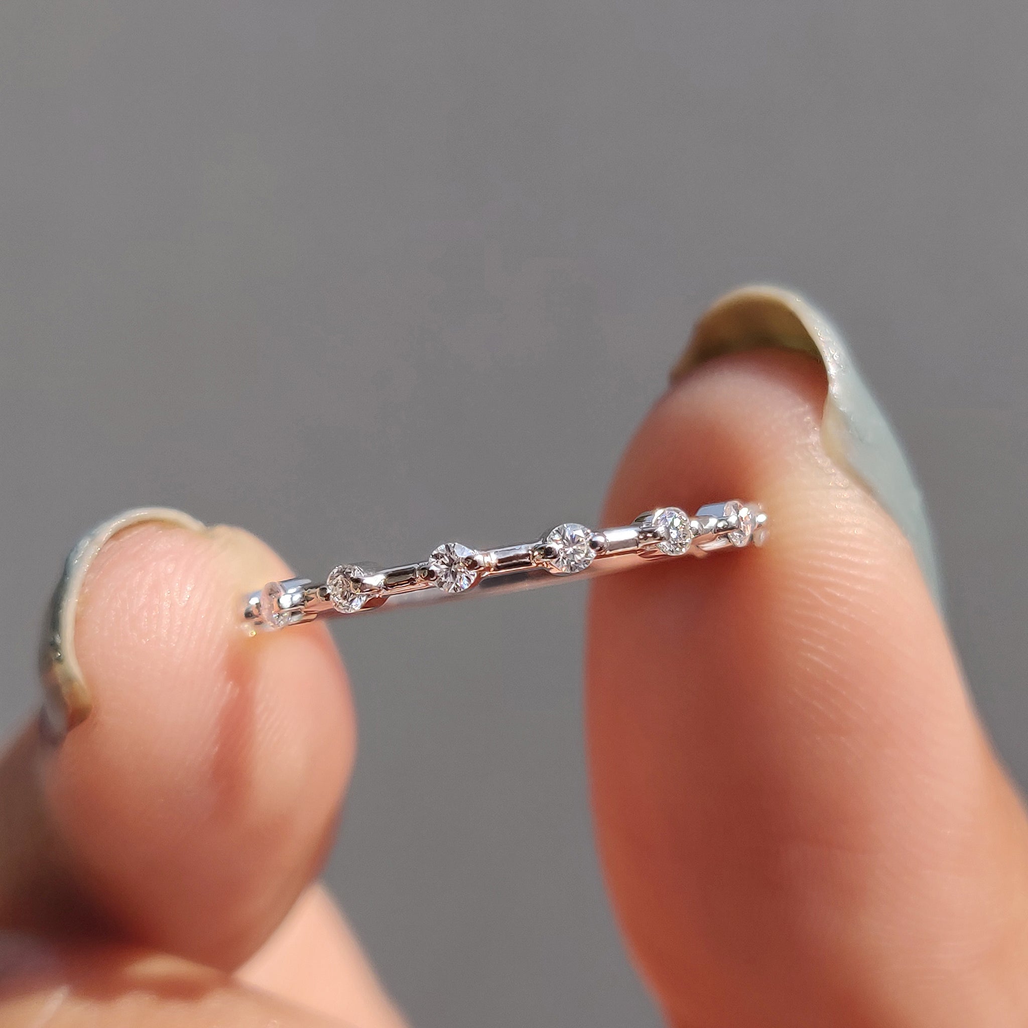 Round moissanite wedding band with a sleek design.