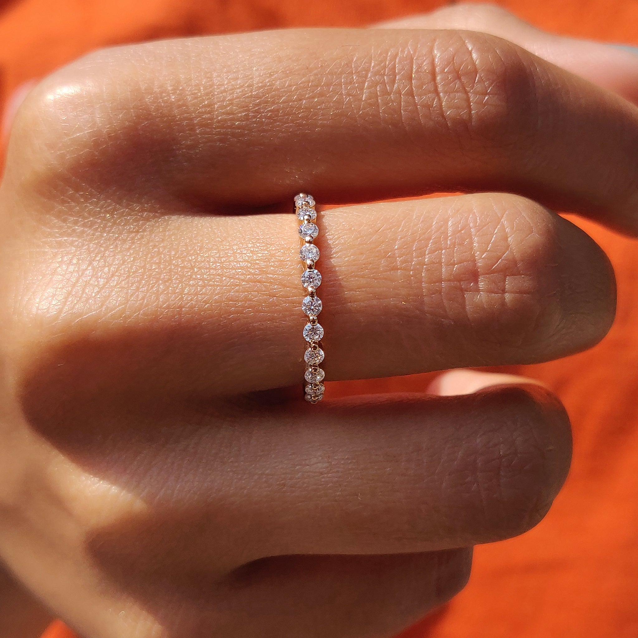 Eternity wedding band featuring brilliant round-cut diamonds in rose gold.