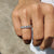 Double style eternity band featuring alternating emerald and round moissanite stones.