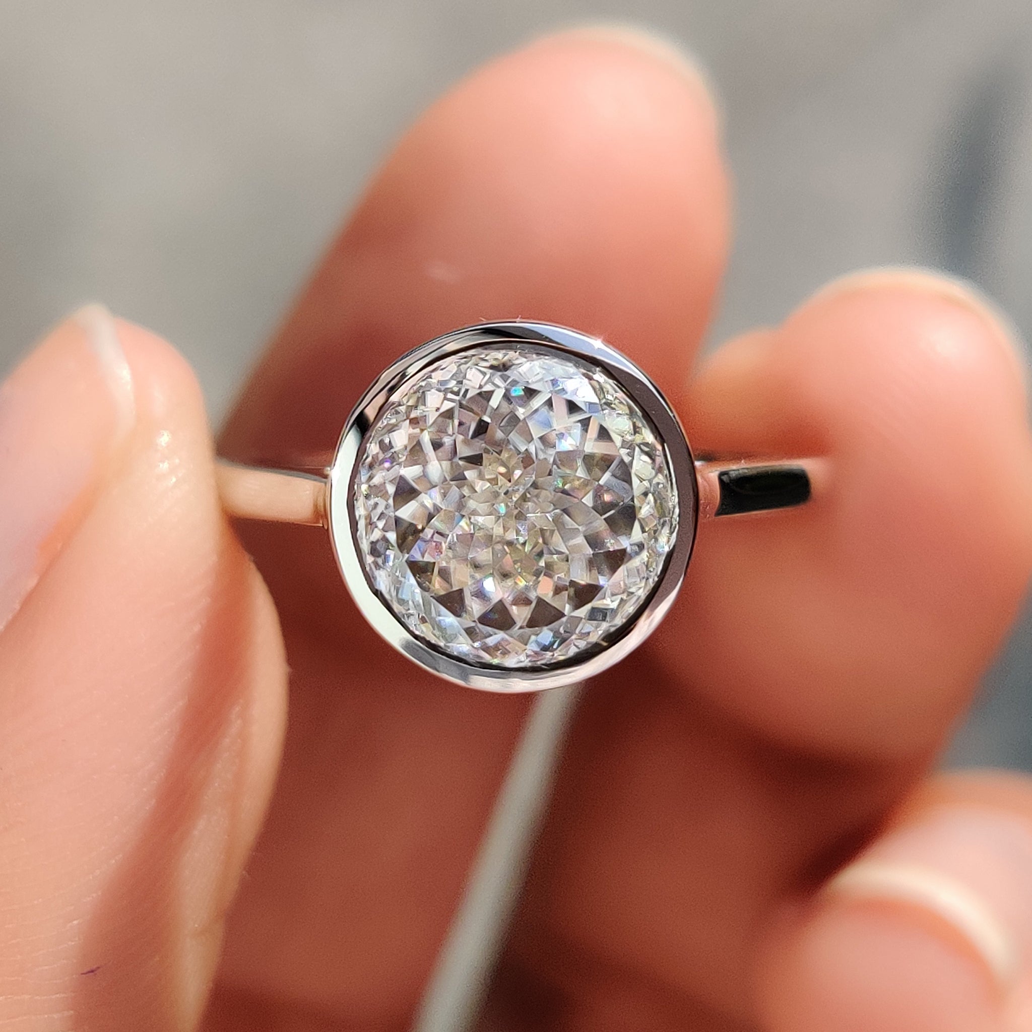 This bezel set engagement ring features a secure and sleek design.
