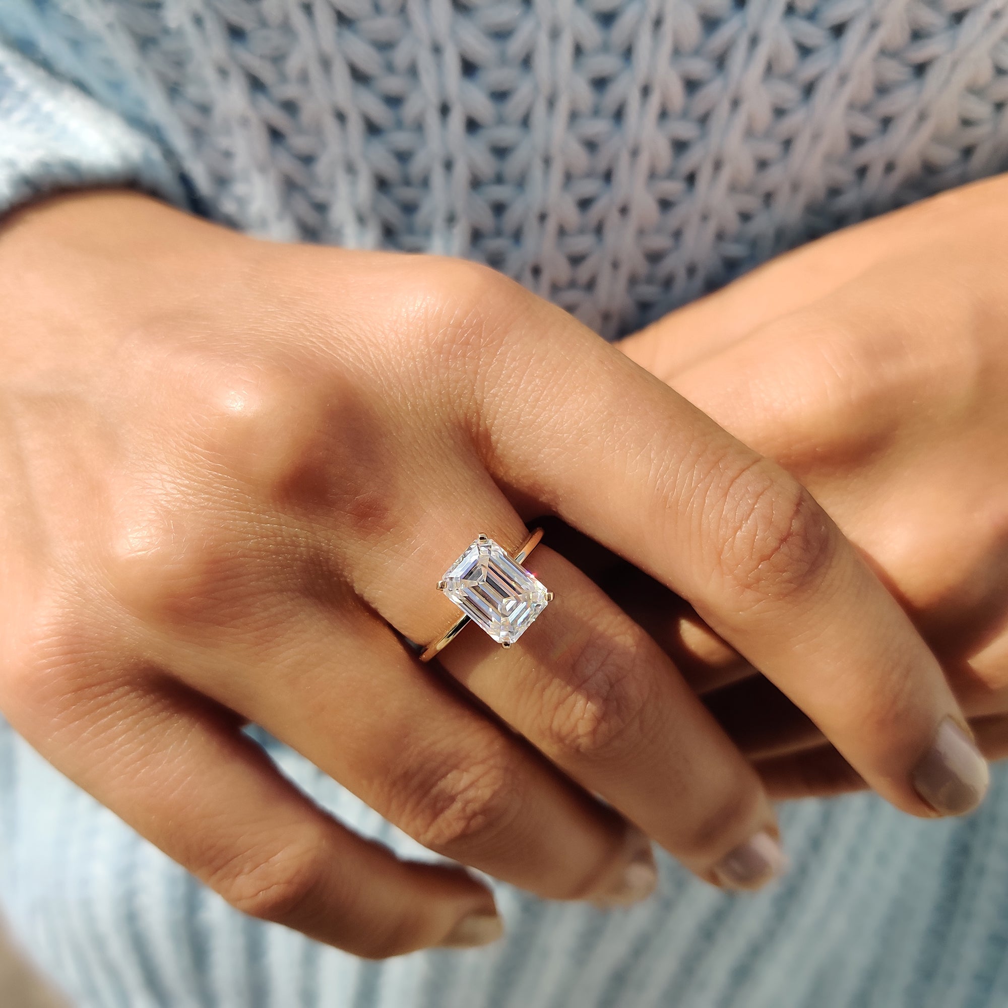 Knife edge ring featuring emerald cut center stone.
